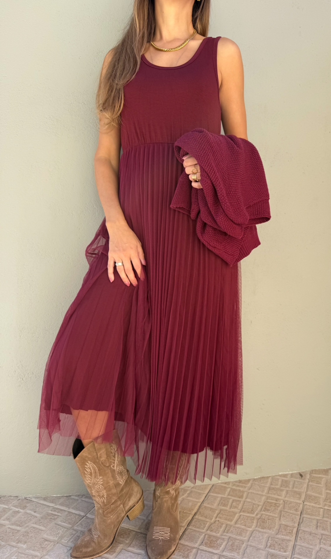 Vestido borgonha longo plissado com casaco e botas de couro bege.