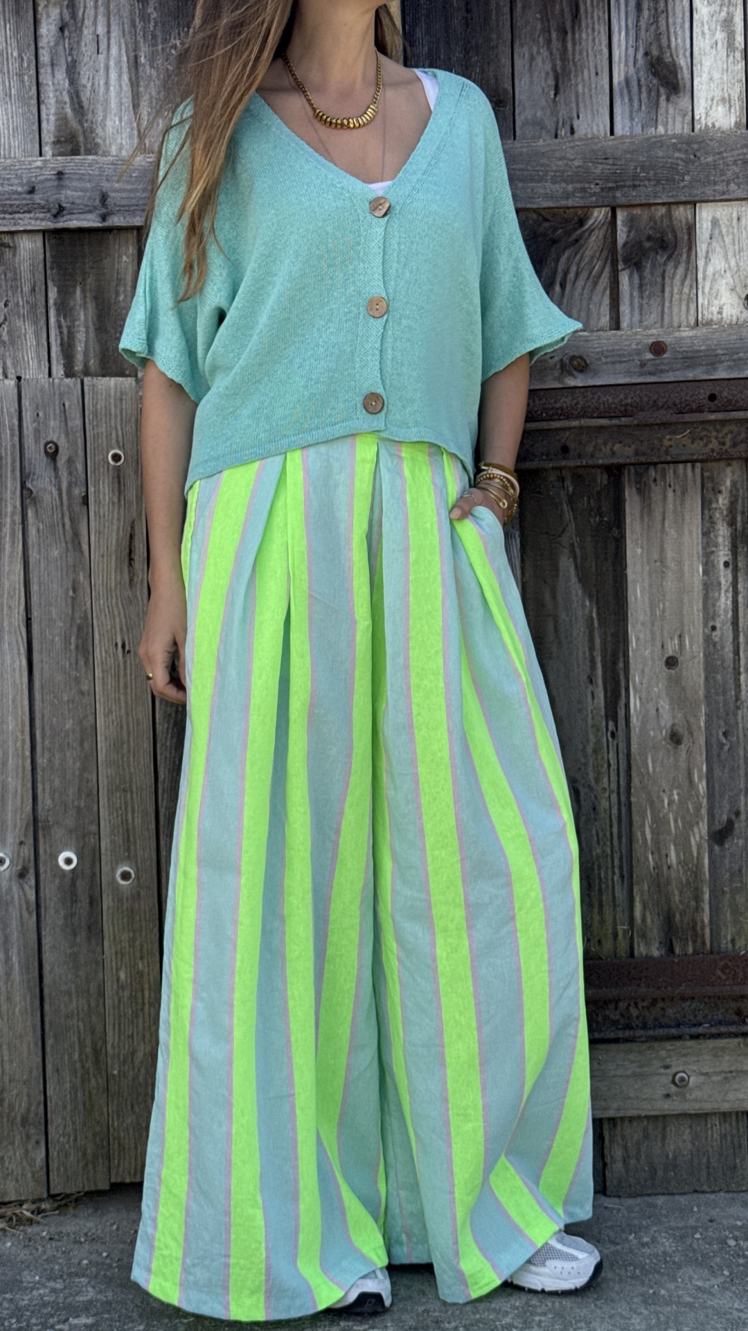 Conjunto com camisola curta verde água e calças largas às riscas verde fluorescente, azul e rosa