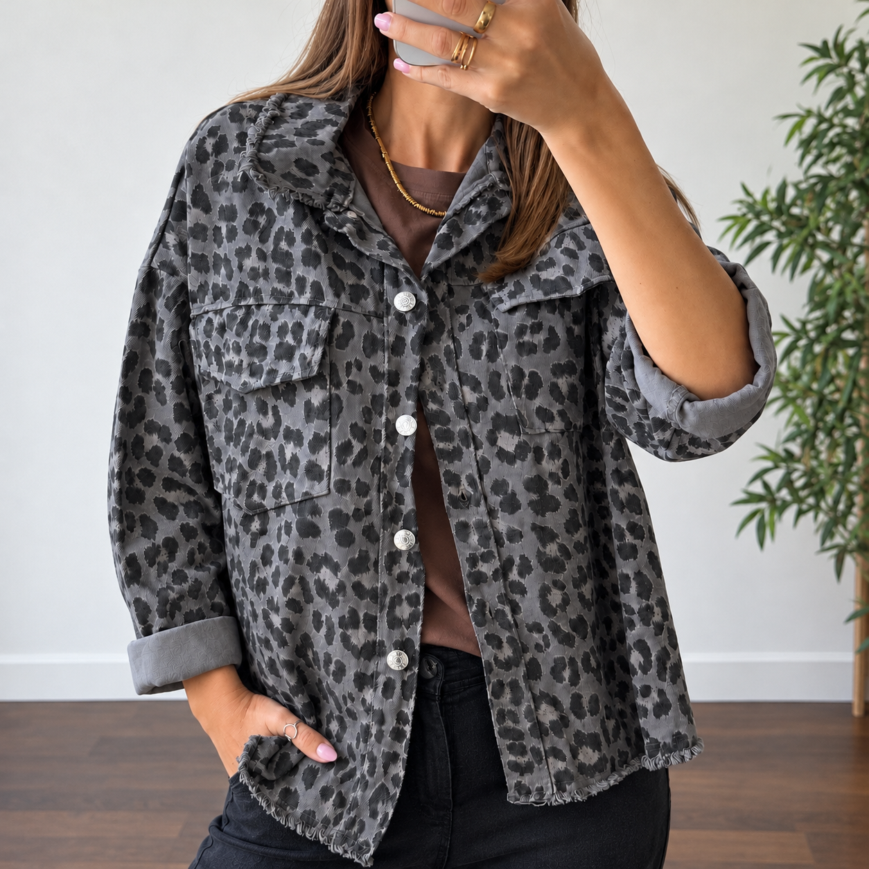 Casaco cinza animal print com botões prateados e bolsos grandes em interior com chão de madeira