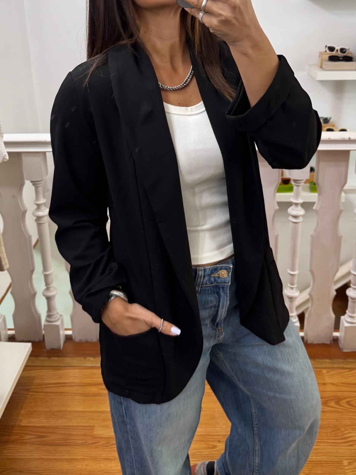 Blazer preto, top branco e jeans azuis