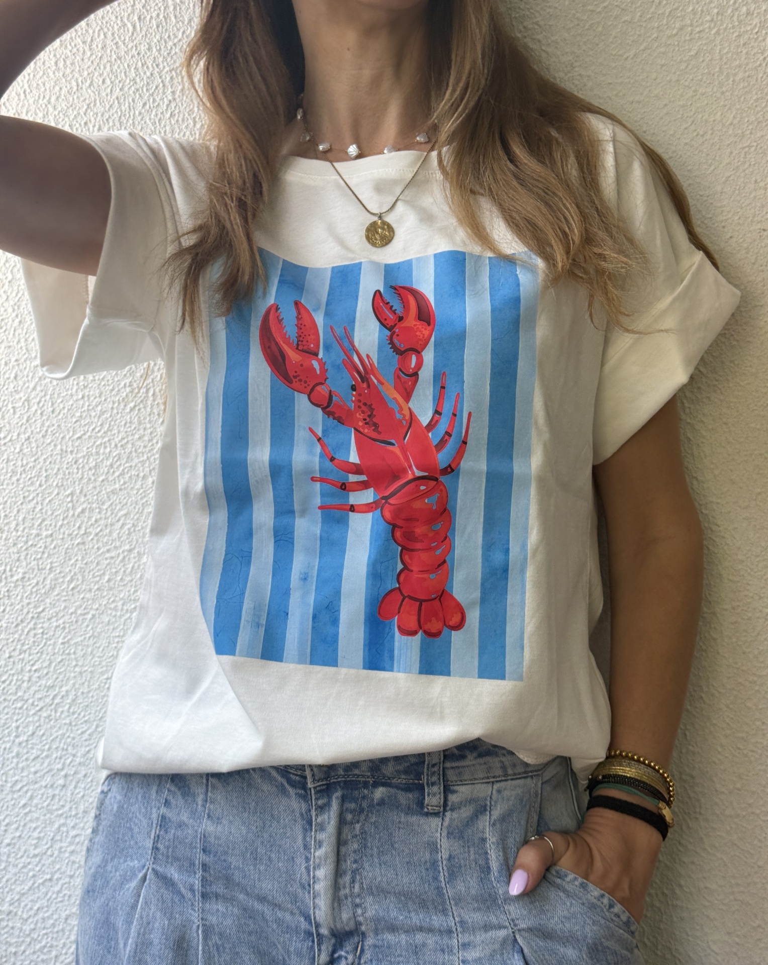 Camiseta branca com lagosta vermelha e riscas azuis