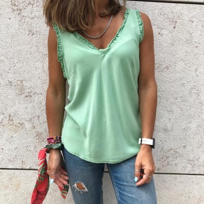 Top verde com folhos nas alças e decote em V usado com jeans rasgados