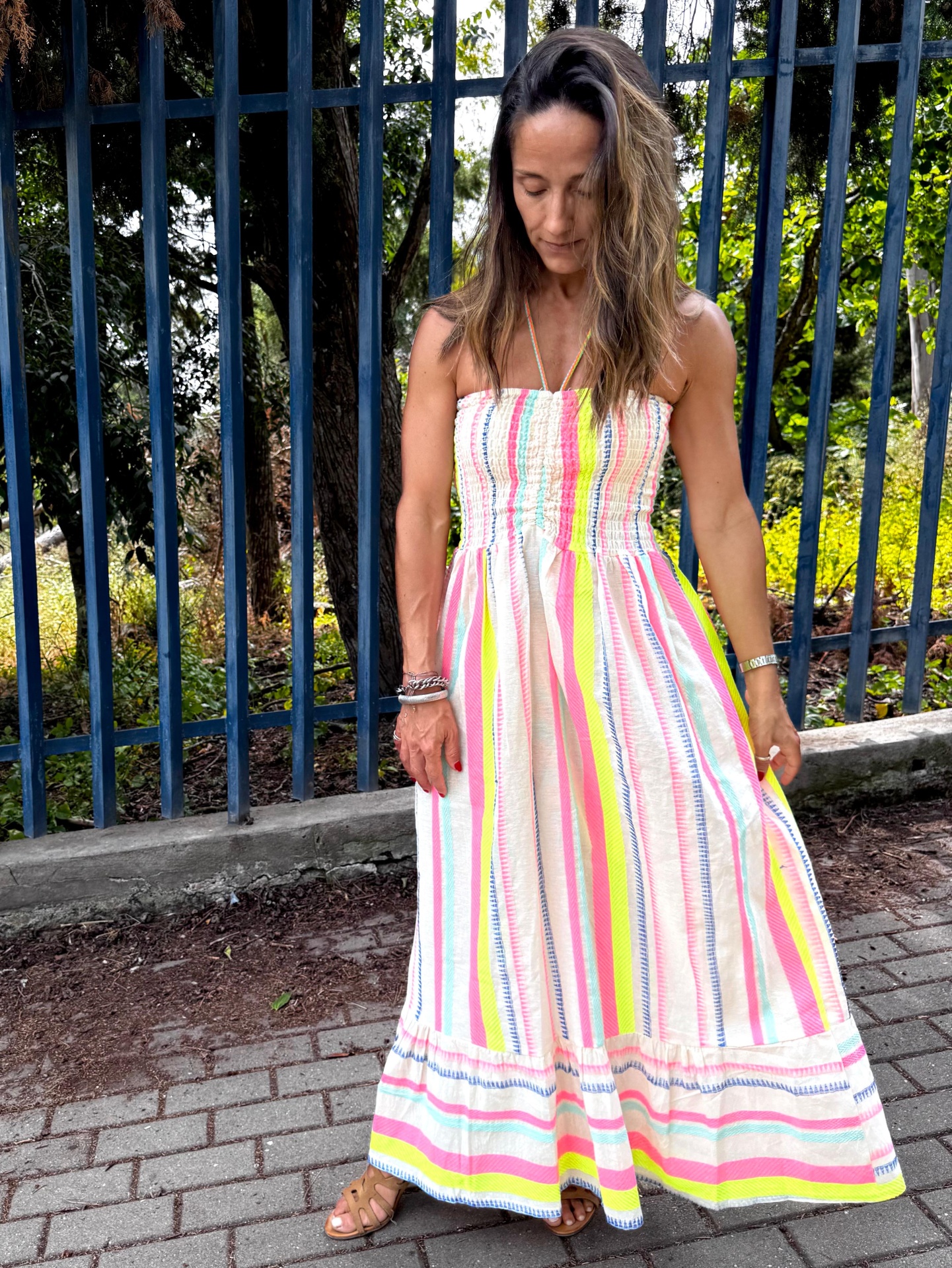 Mulher com vestido longo de riscas coloridas em ambiente exterior