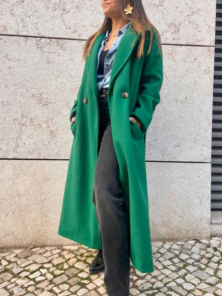 sobretudo verde longo feminino com botões dourados em ambiente urbano