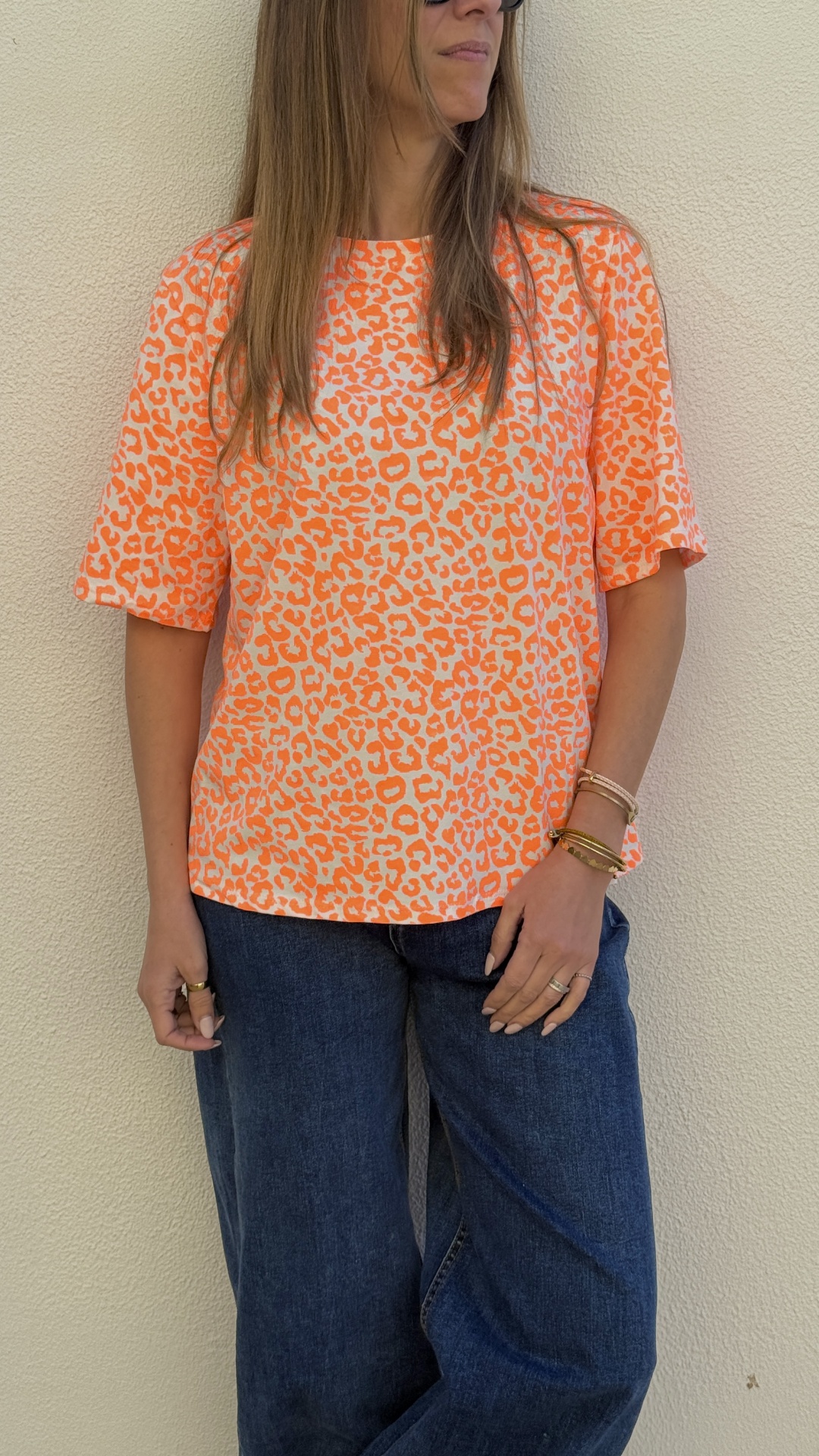 T-shirt animal print laranja e branco com calças de ganga azuis e acessórios femininos