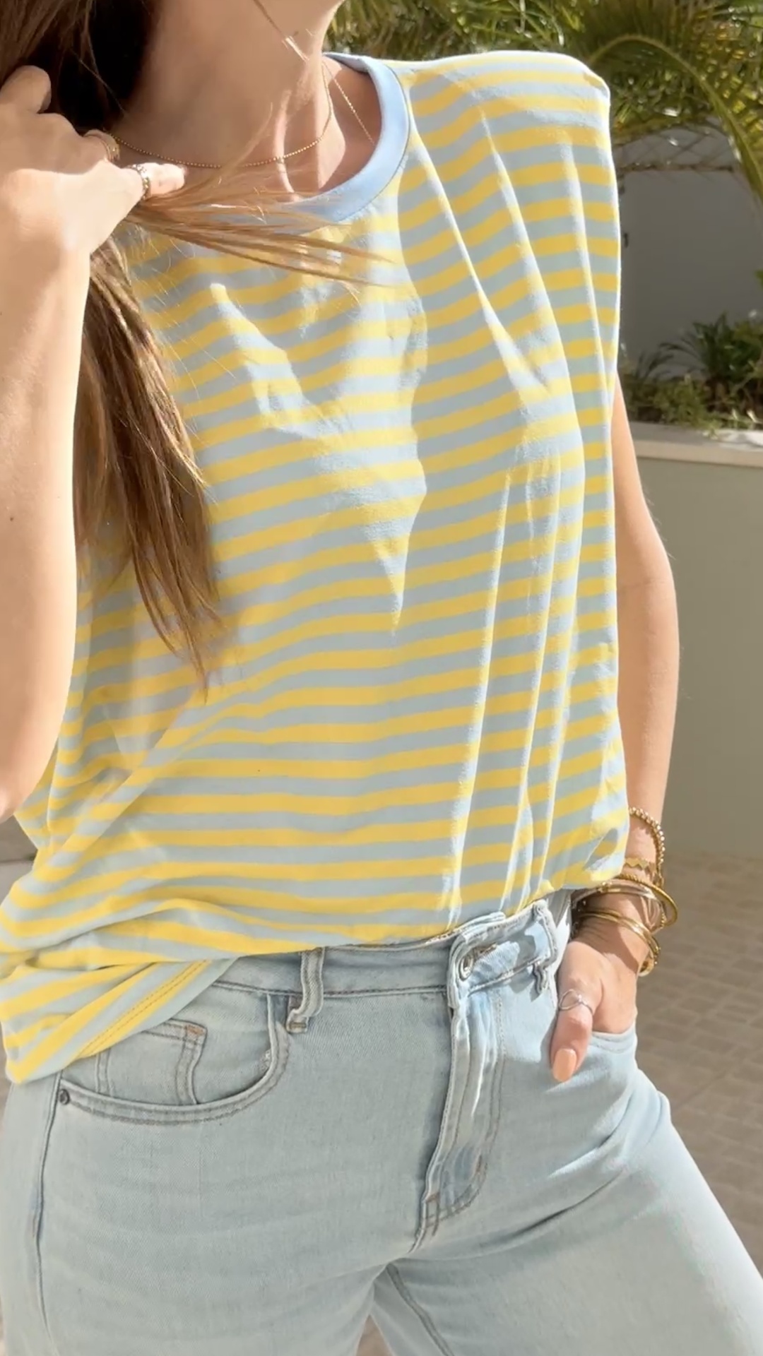 T-shirt às riscas amarelas e azuis claras e calças de ganga azul clara