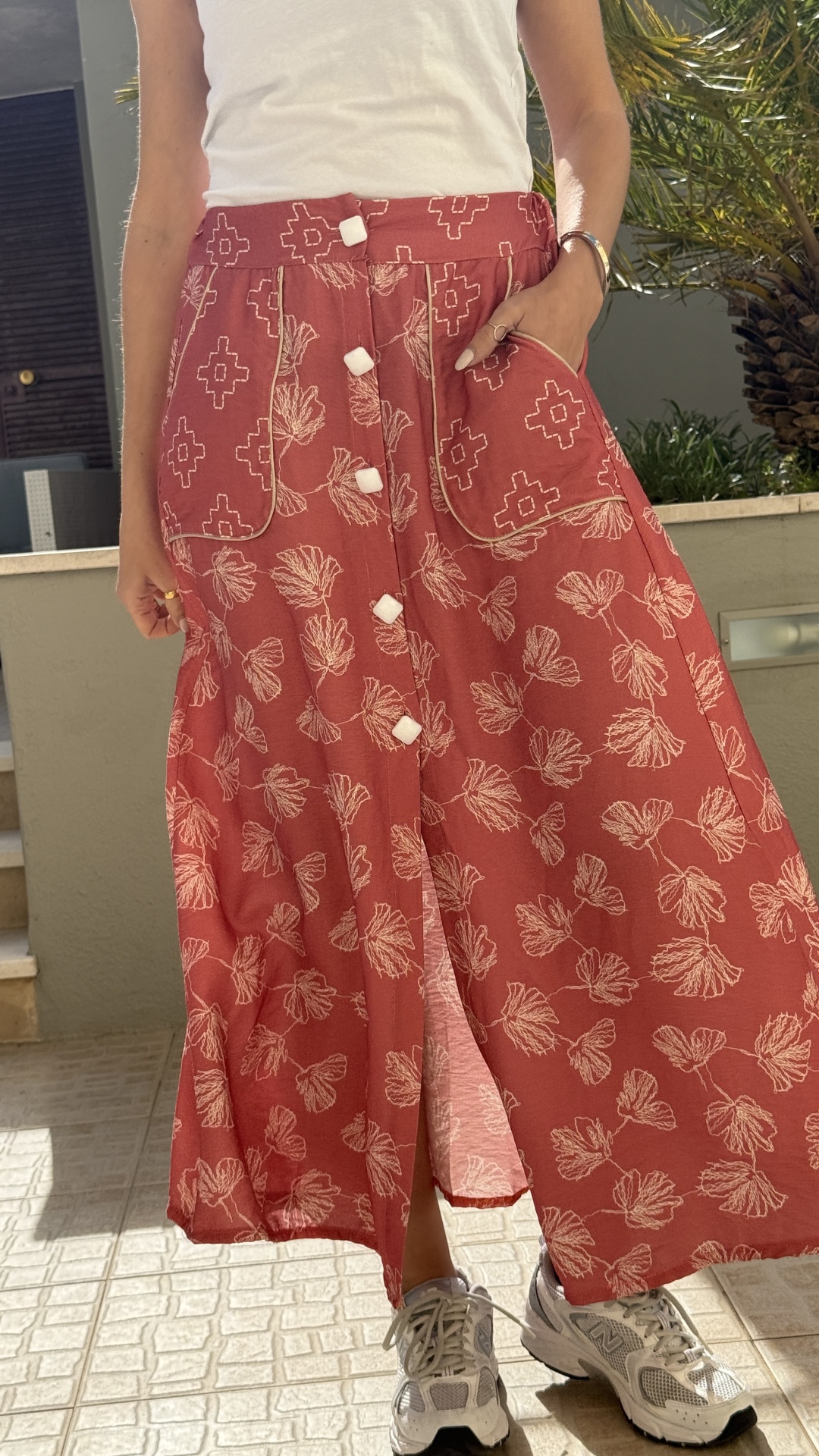 Saia midi vermelha com padrão floral branco e botões brancos