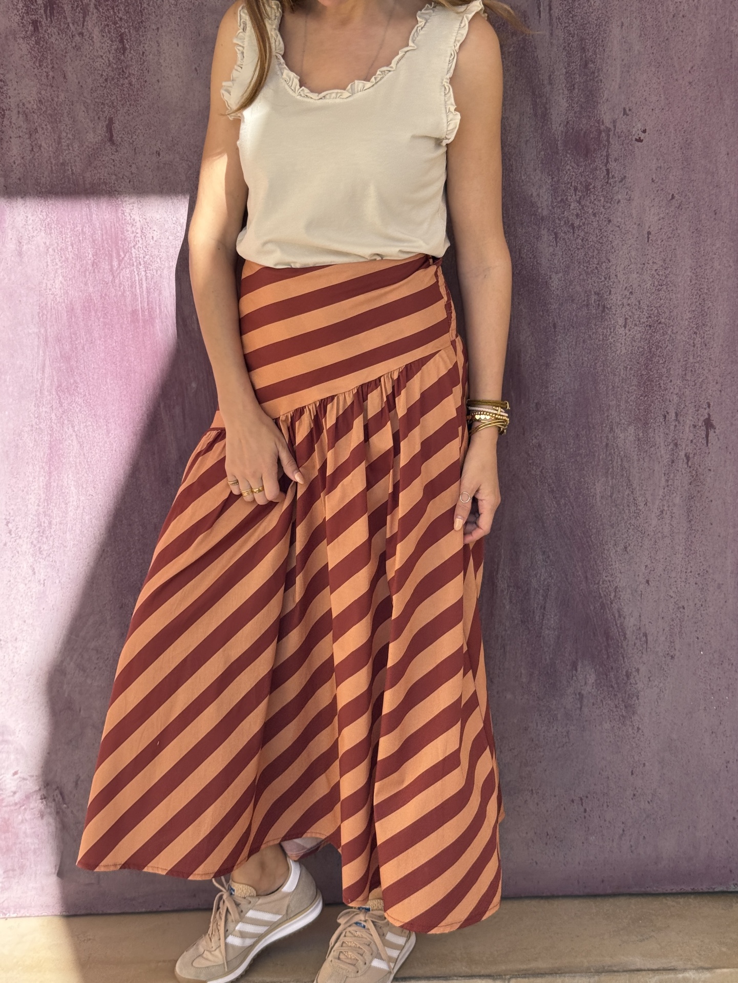 Conjunto feminino com top bege e saia midi riscada castanho e laranja.