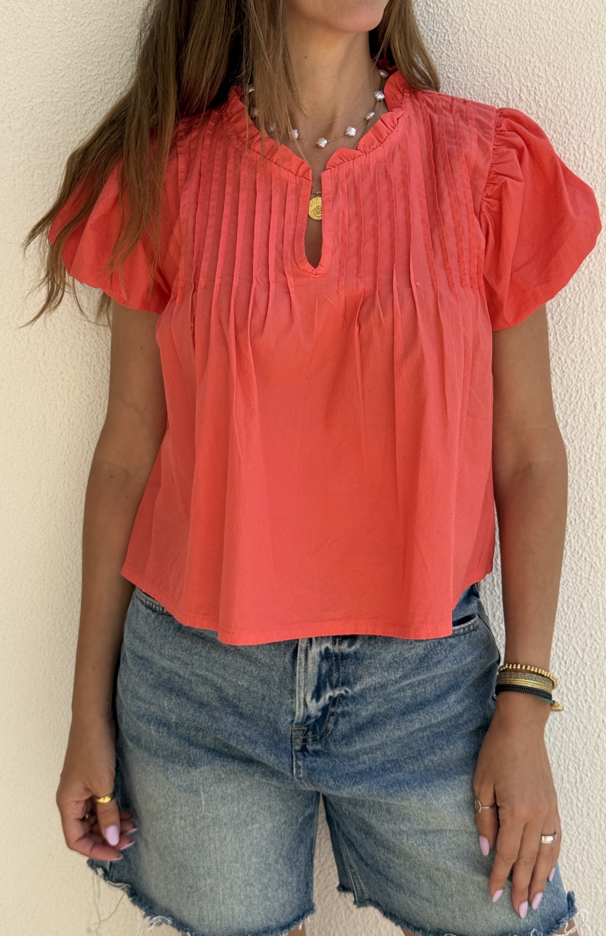 Top feminino coral com pregas verticais e calções de ganga azuis claros