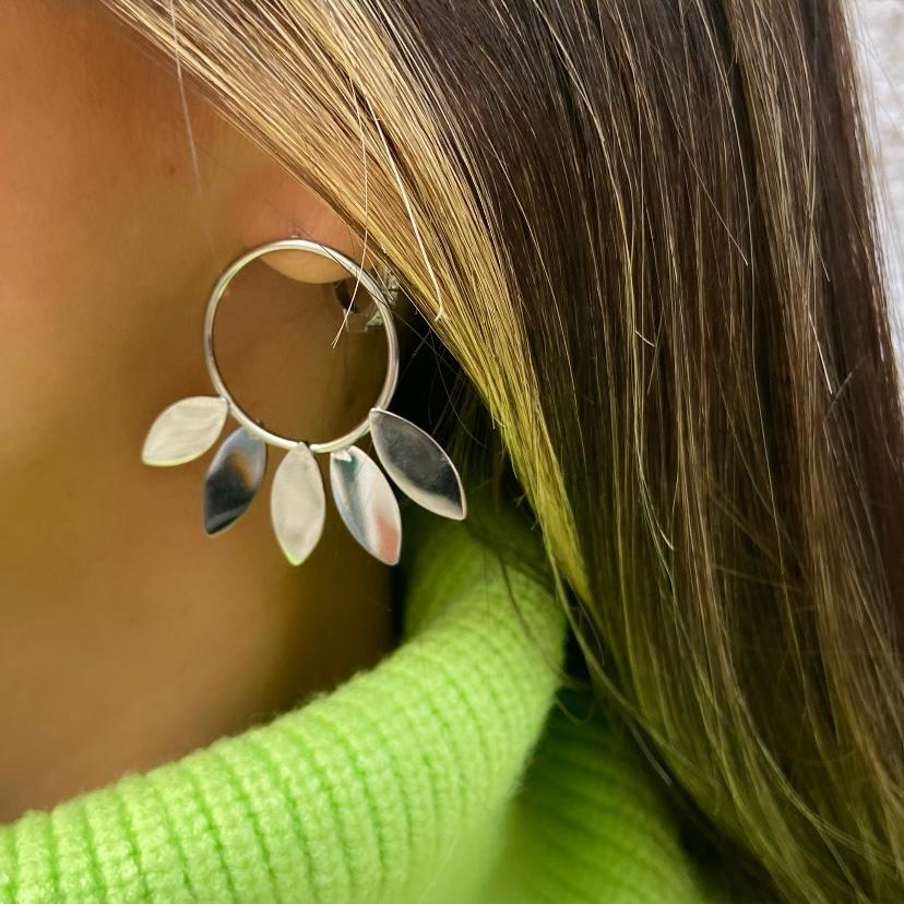 Brinco prateado em forma de argola com folhas penduradas no ouvido