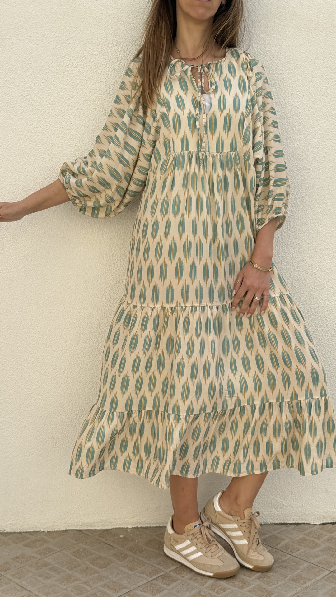 Vestido comprido estampado com sapatilhas Adidas bege no chão