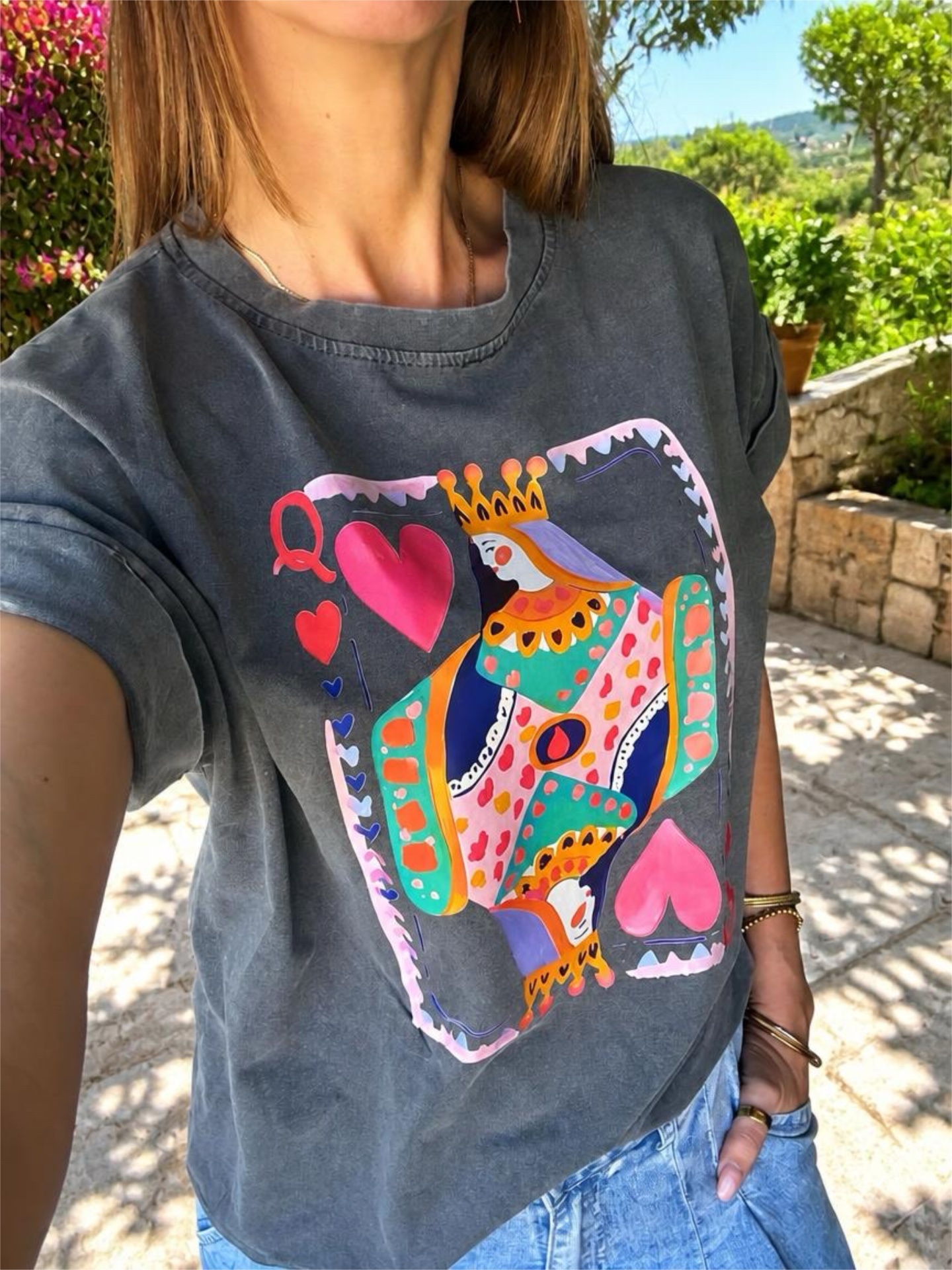 T-shirt cinza escuro com estampa colorida da Rainha de Copas e jeans azul claro