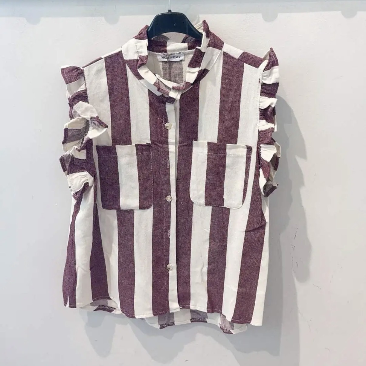 Camisa sem mangas às riscas branco e bordô com folhos nas mangas e bolsos frontais.