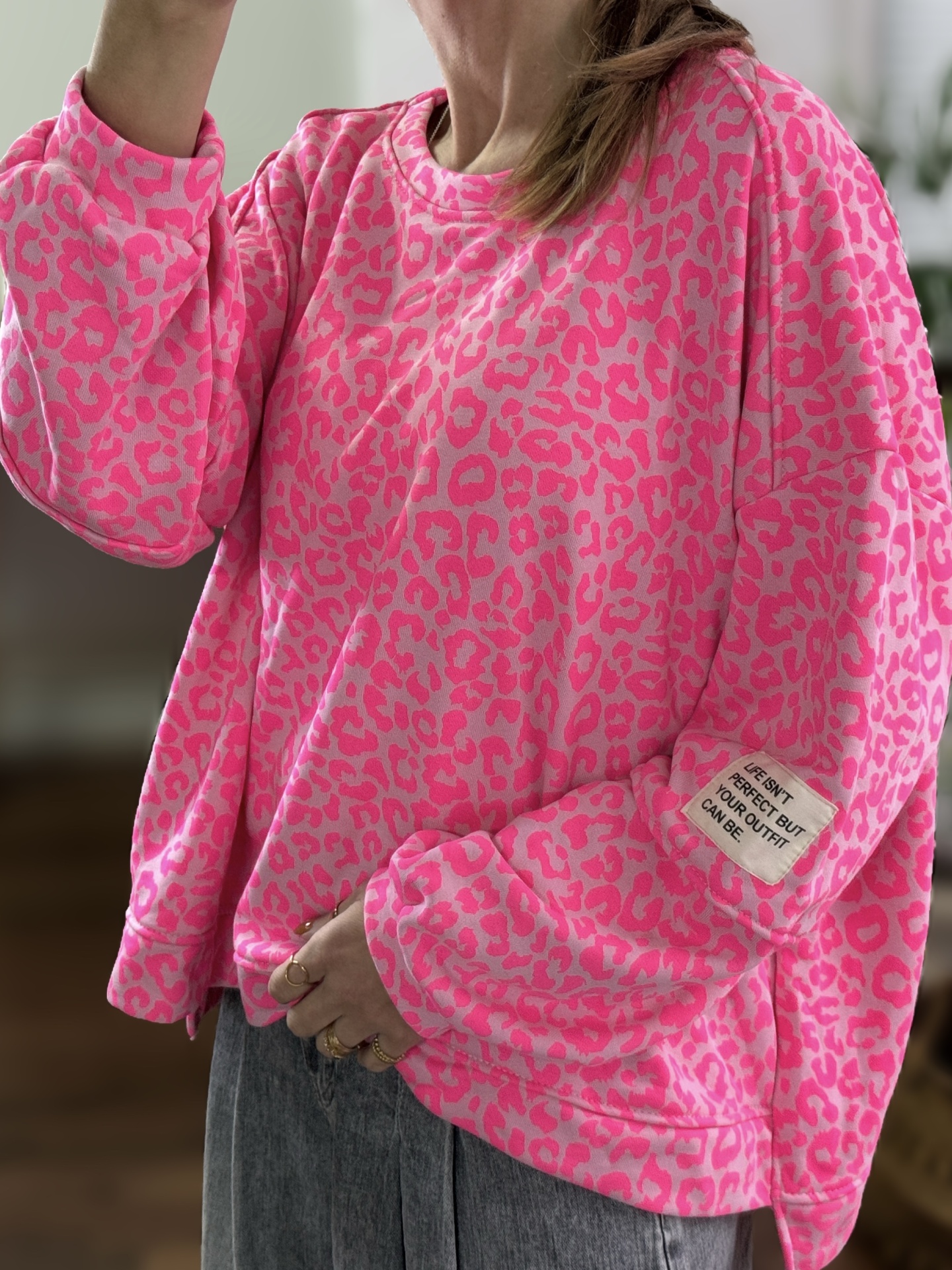 Sweatshirt rosa com padrão animal print e etiqueta na manga com texto