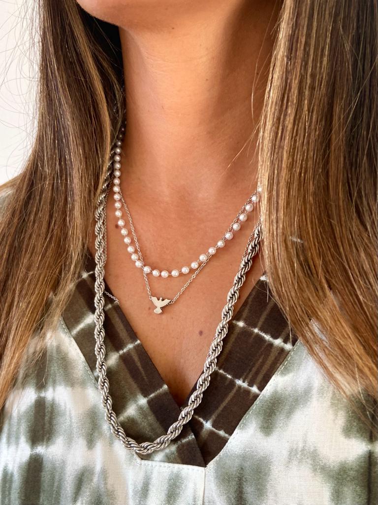 Colar de pérolas e corrente com pendente de pá usado por mulher