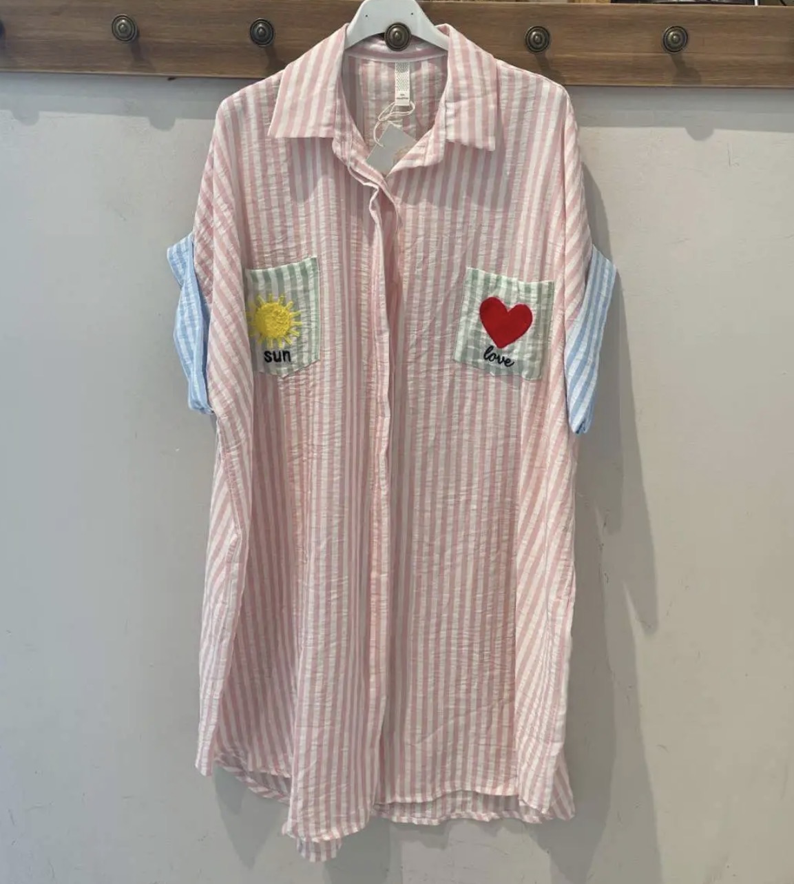 Camisa comprida rosa às riscas com bolsos bordados e mangas azul claro