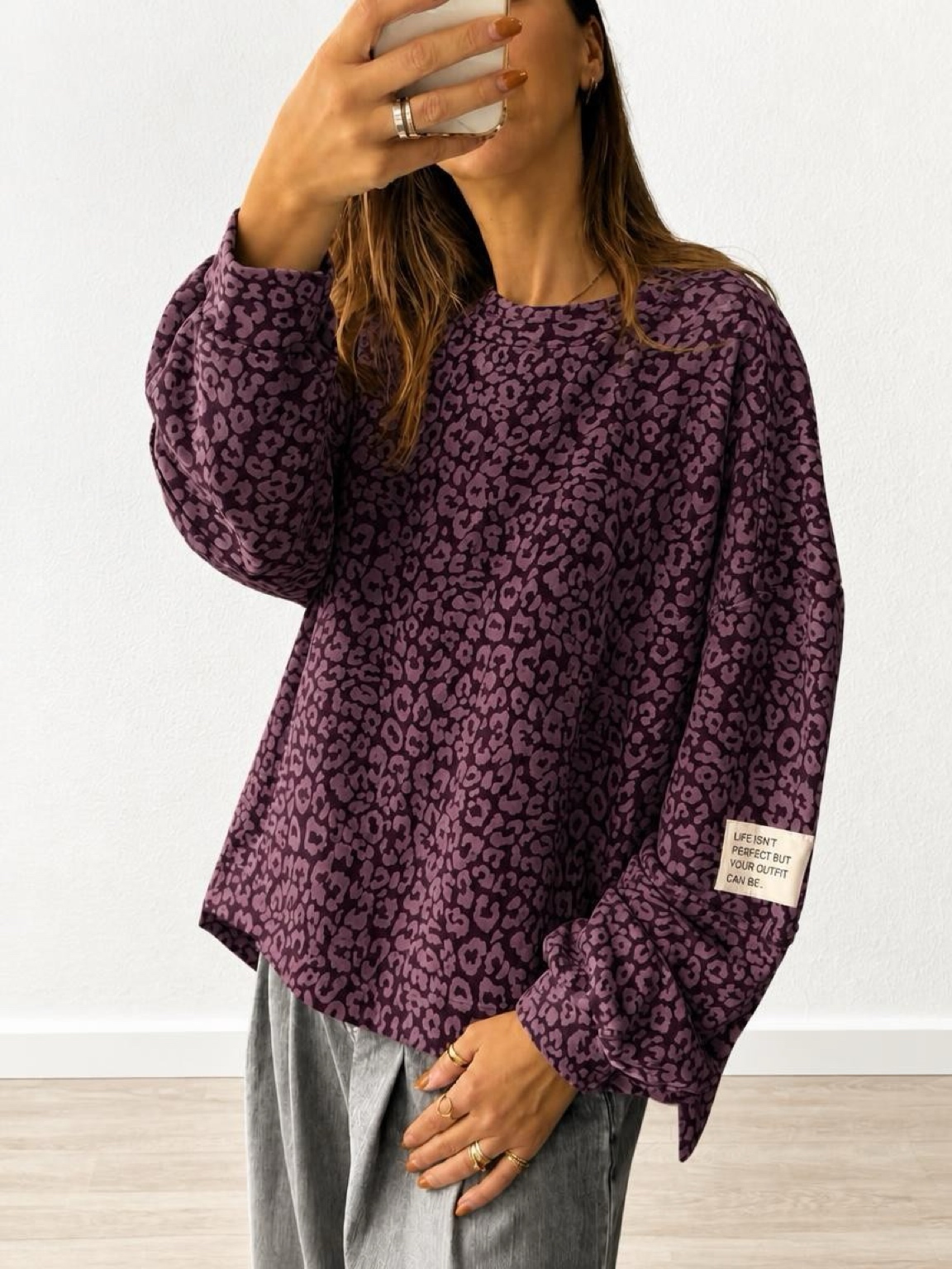 Camisola roxa com padrão leopardo e etiqueta com texto na manga