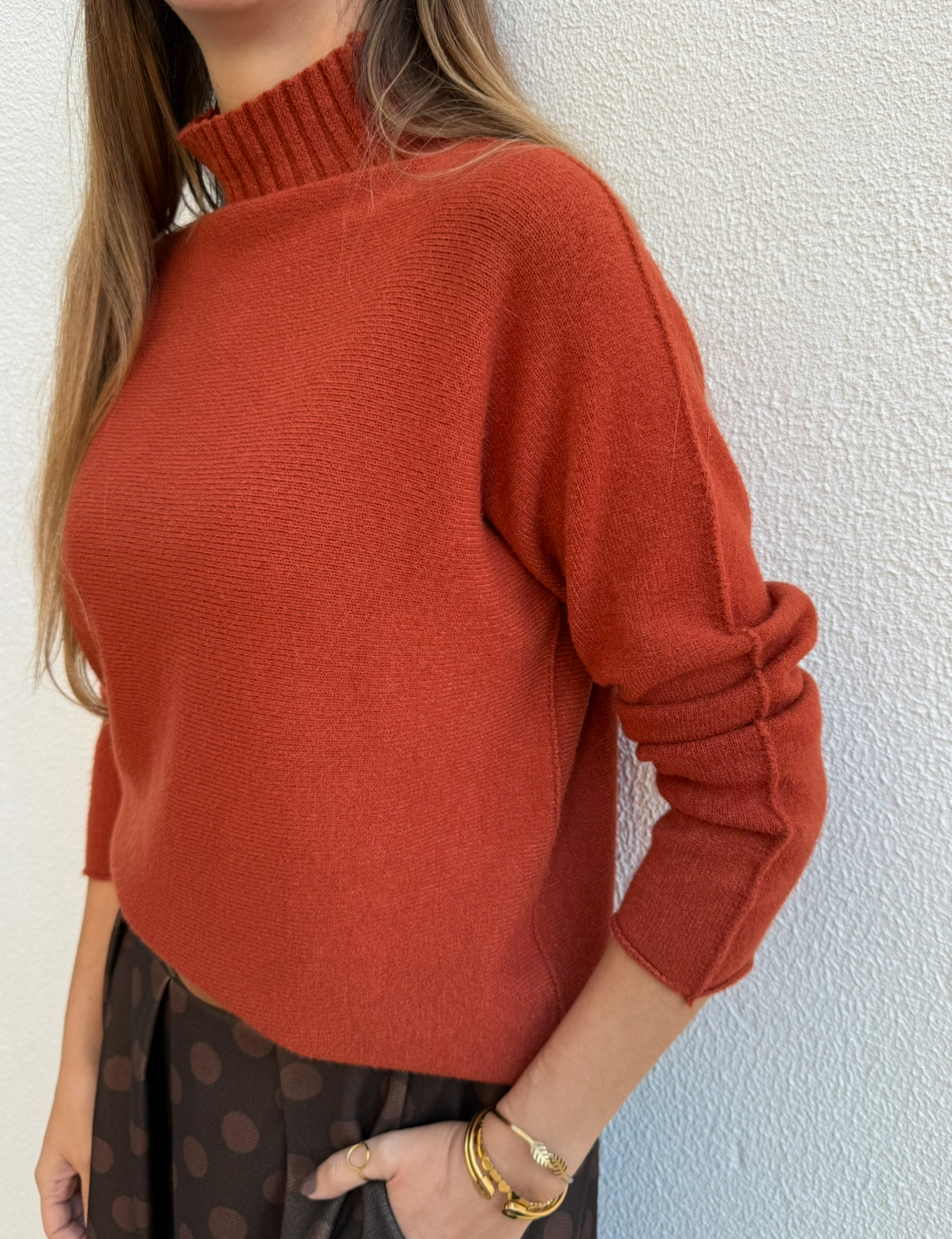 Camisola vermelha de malha com gola alta e mangas compridas.