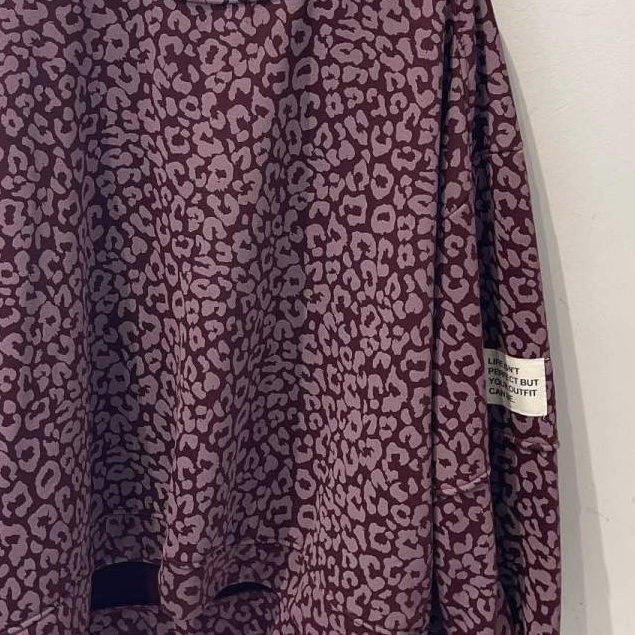 Roupa com padrão estampado animal print roxo e etiqueta visível