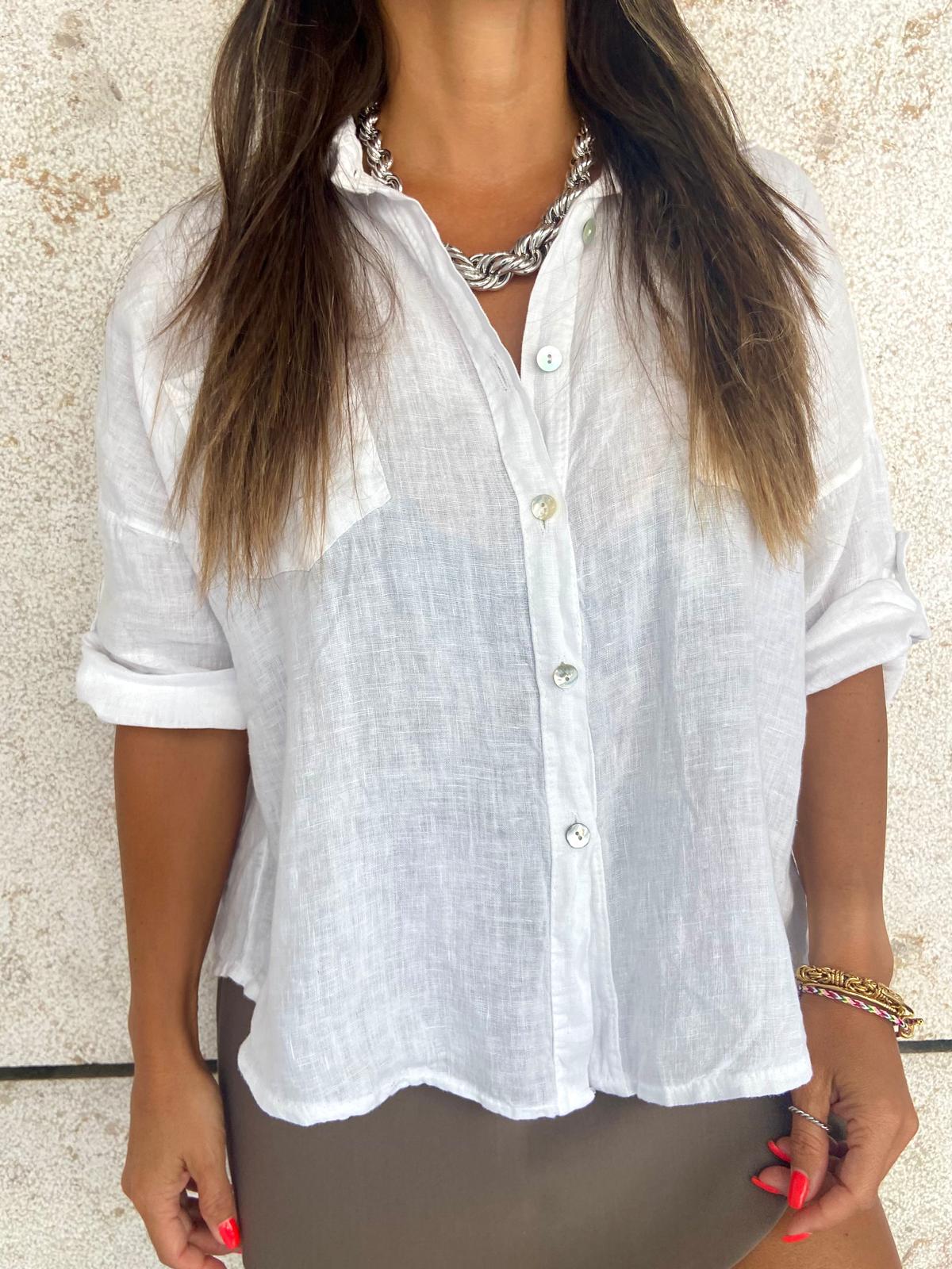 Camisa branca leve com botões usada por mulher com colar e pulseiras