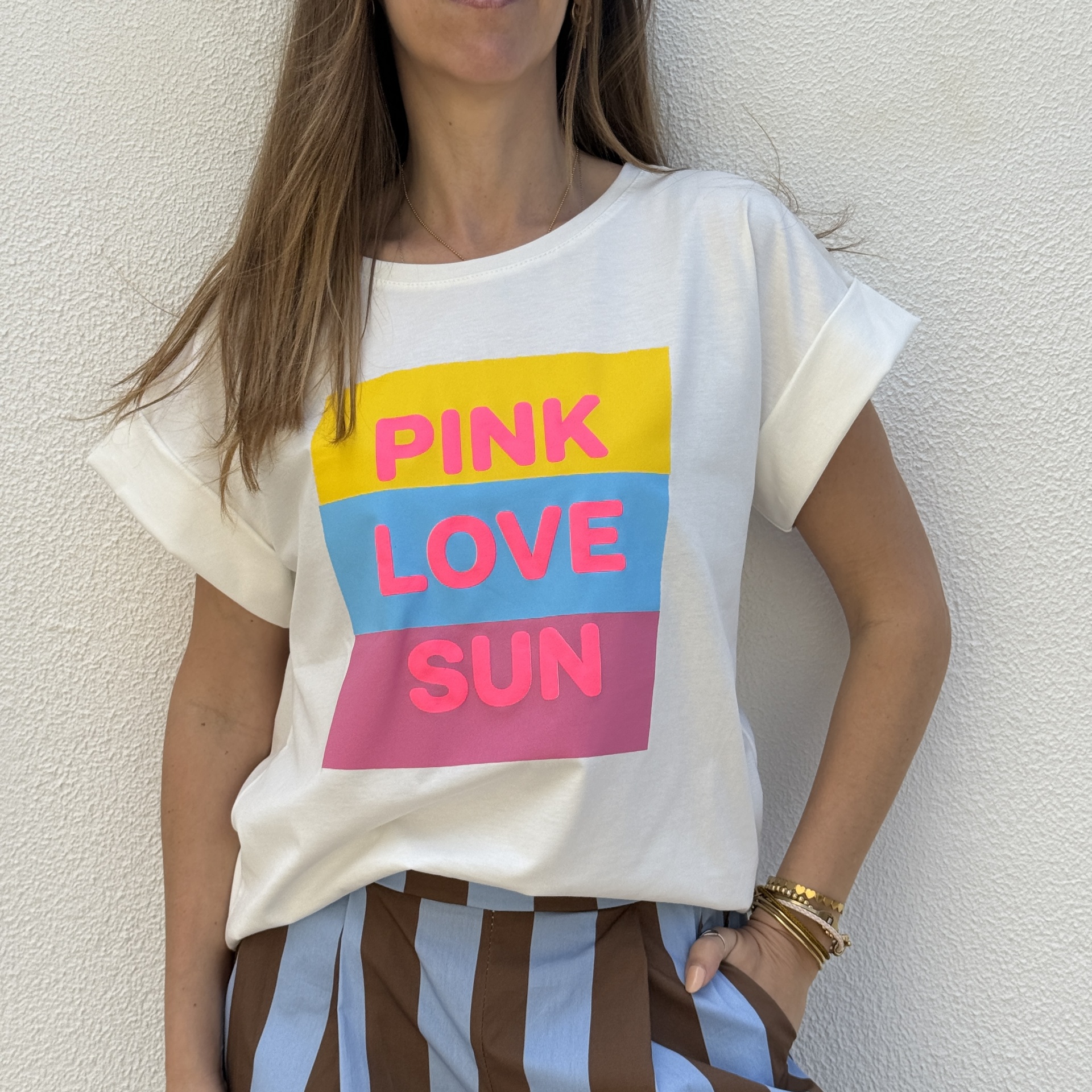T-shirt branca com estampa PINK LOVE SUN e calças listradas azul e castanho