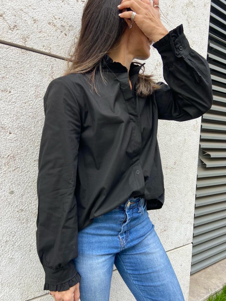 Camisa preta de manga comprida com calças de ganga azul