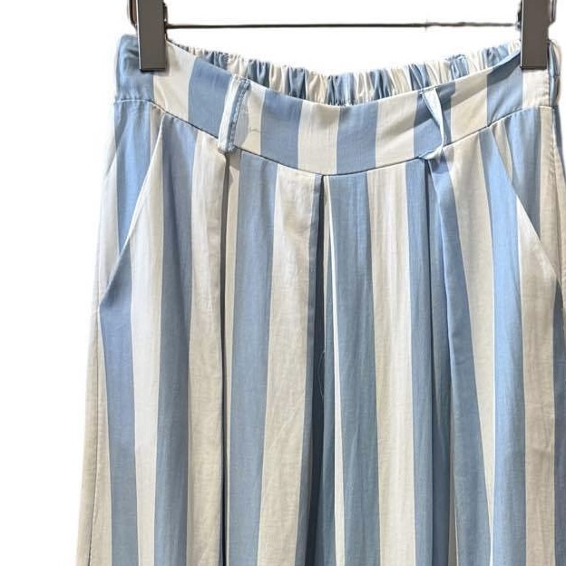 Calças riscas verticais azul claro e branco num cabide