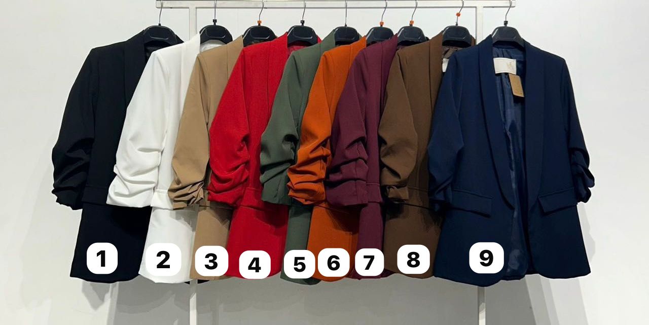 Dez blazers coloridos pendurados num varão com etiquetas numeradas.