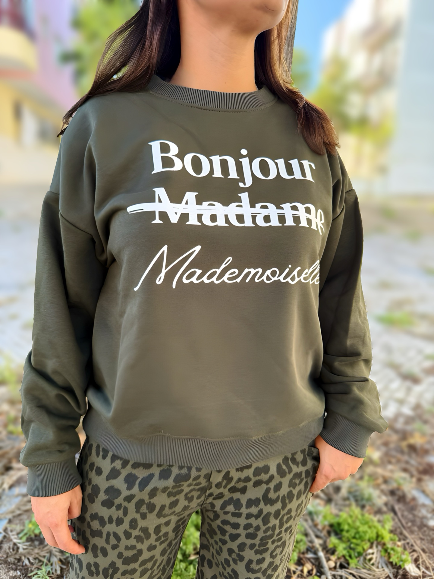 Pessoa com sweatshirt verde escuro e calças animal print