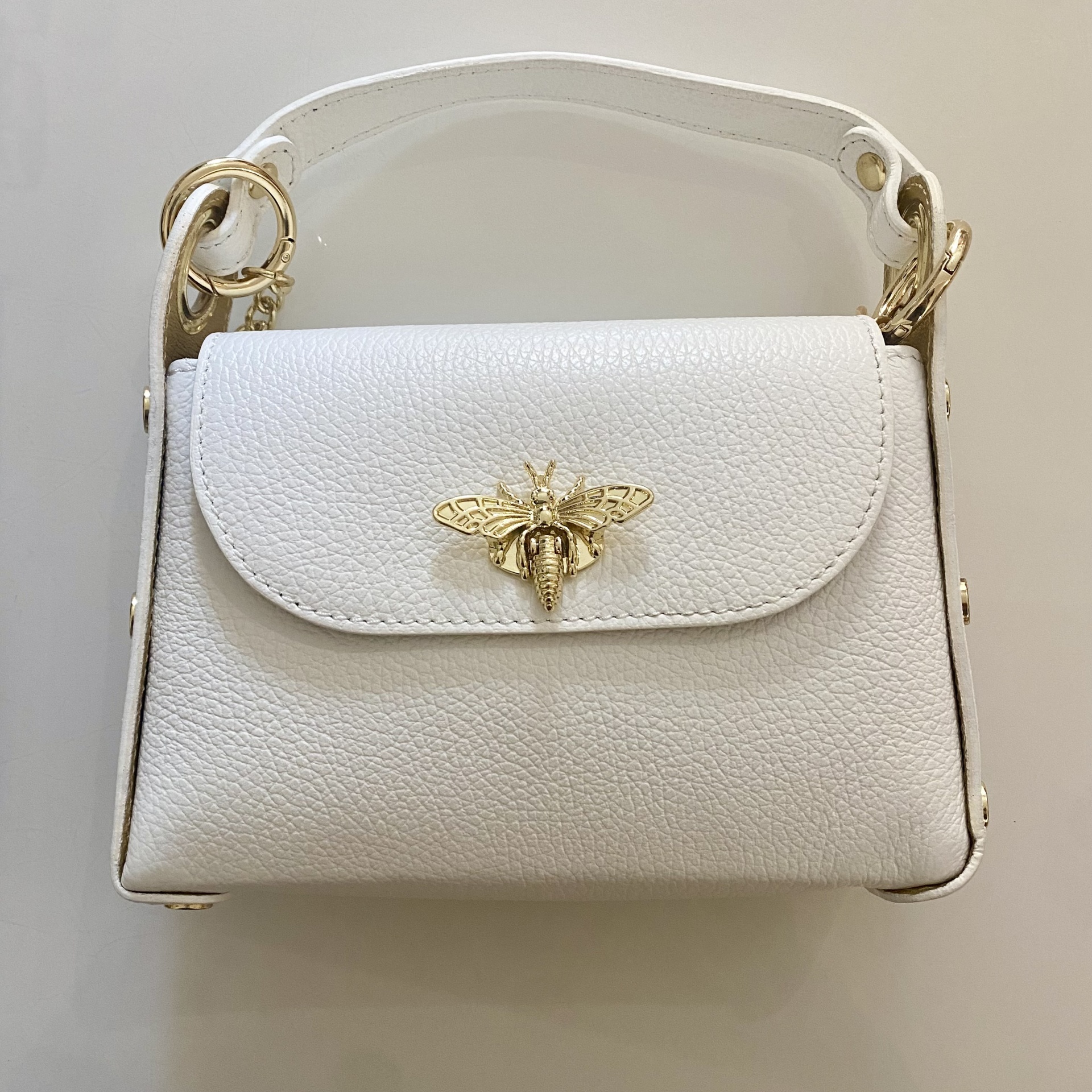 Mala de mão branca com ornamento dourado de abelha