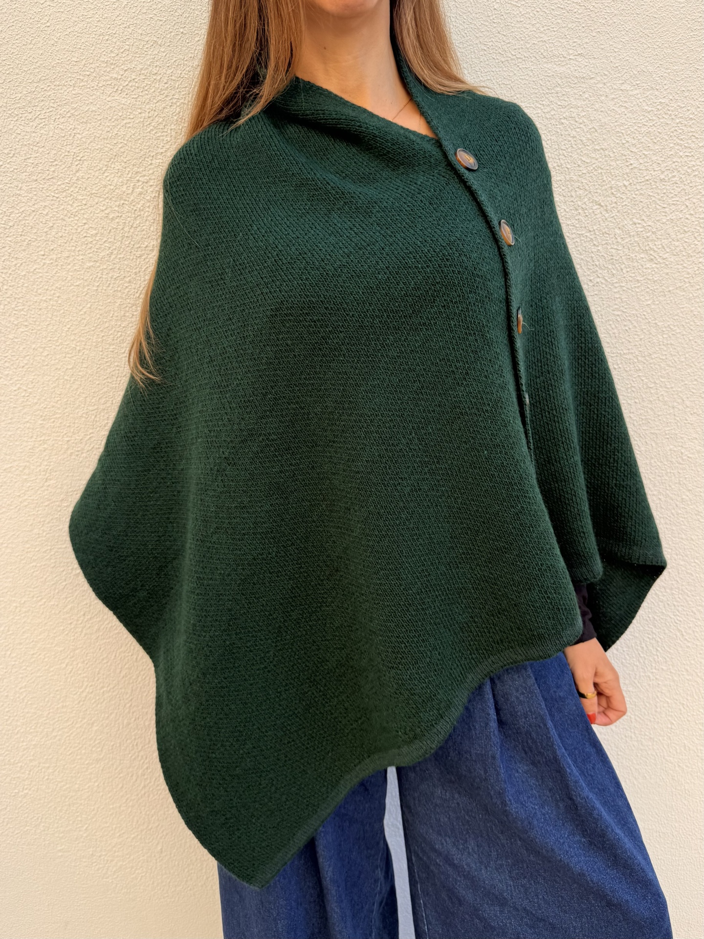 Poncho verde escuro com botões e calças de ganga azul escuro