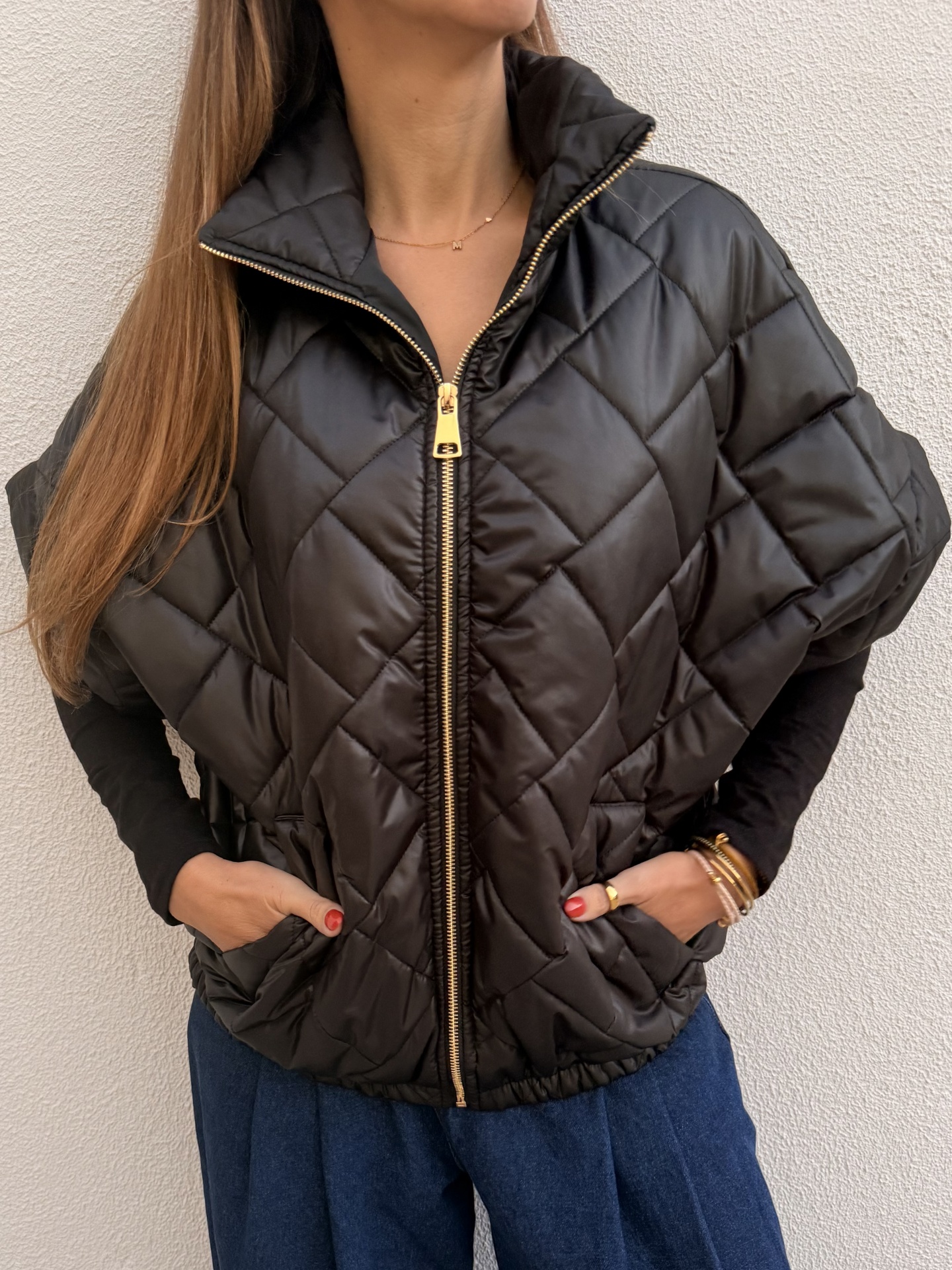 Casaco acolchoado preto com padrão em losangos e fecho dourado