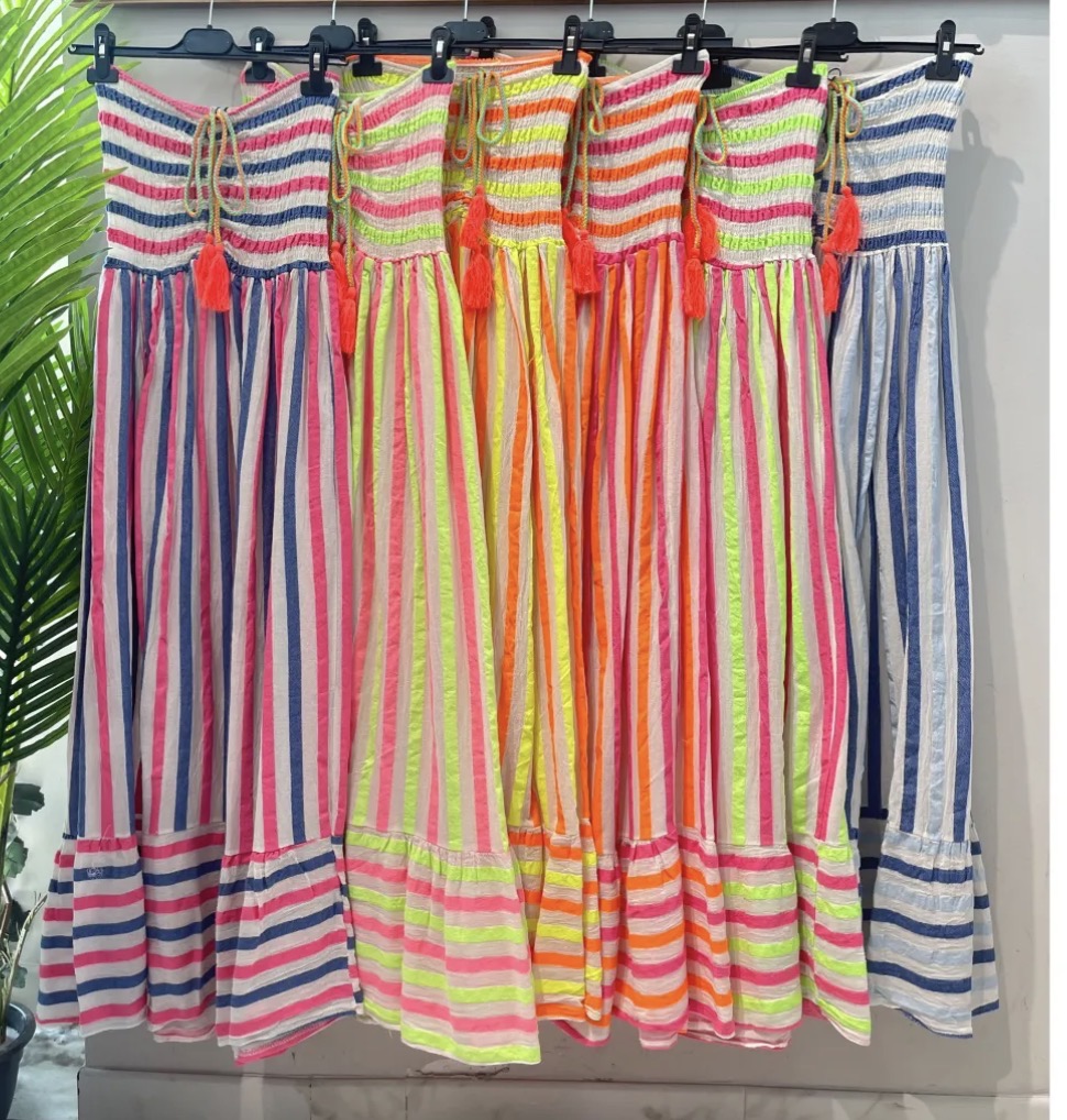Vestidos às riscas coloridas pendurados em cabides pretos