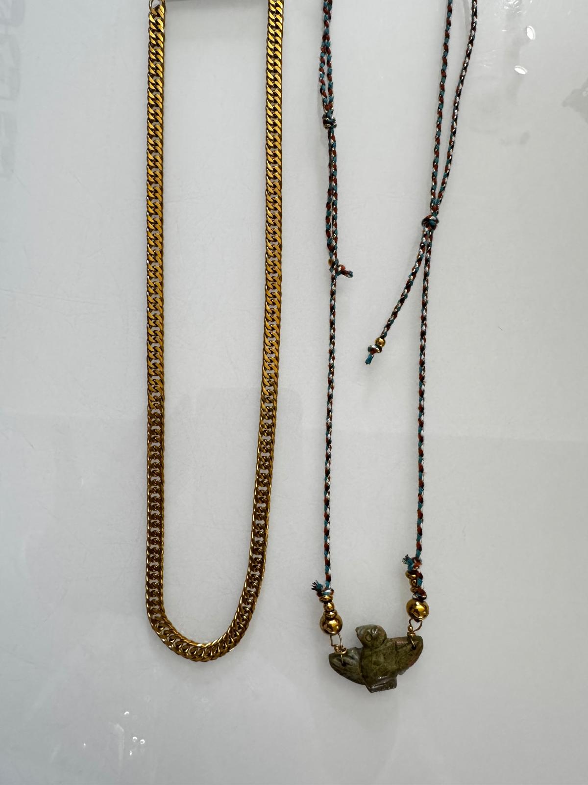 Dois colares, um dourado e um com corda e pendente de pássaro verde
