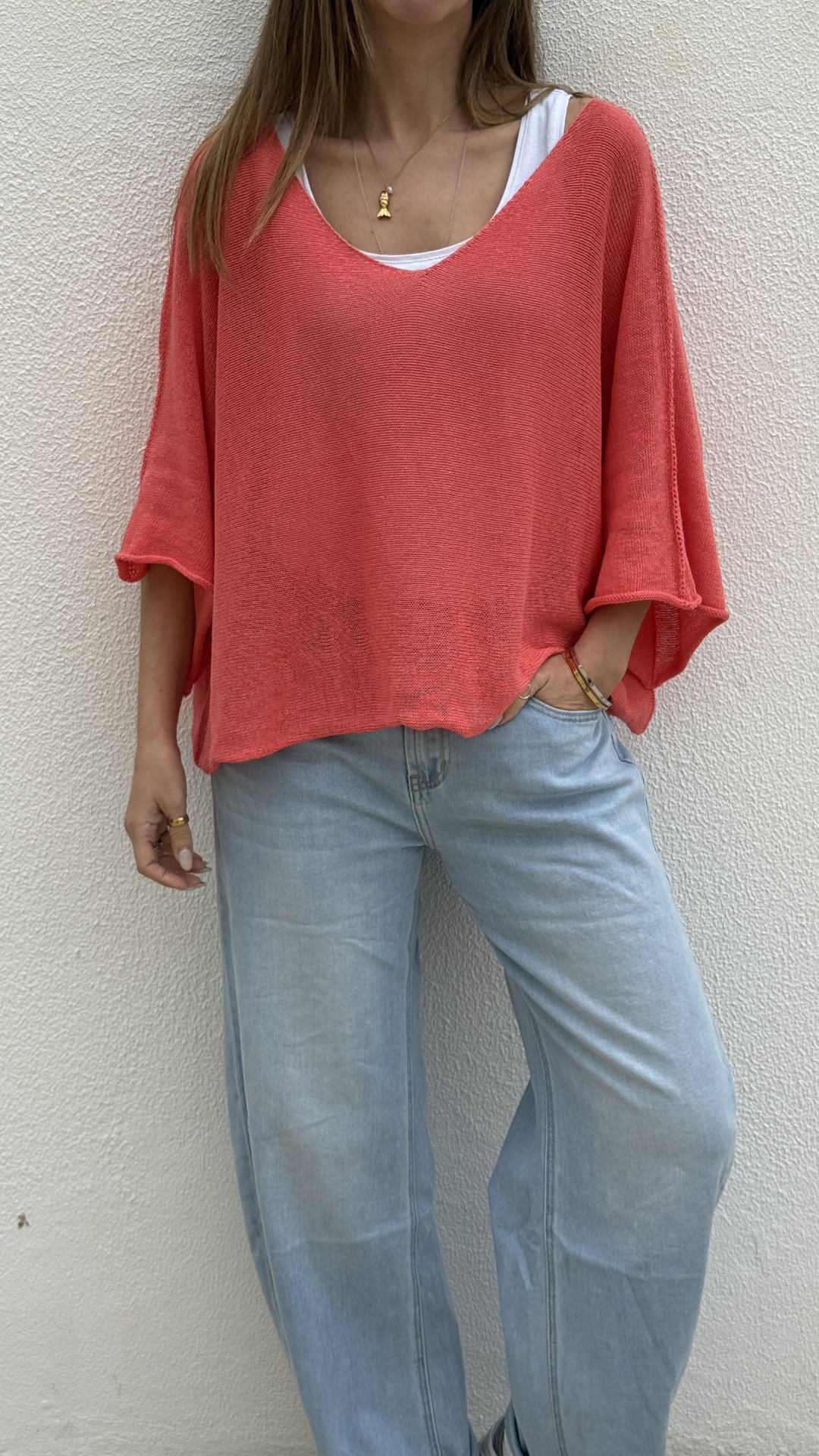 Top coral de malha com calças de ganga largas claras