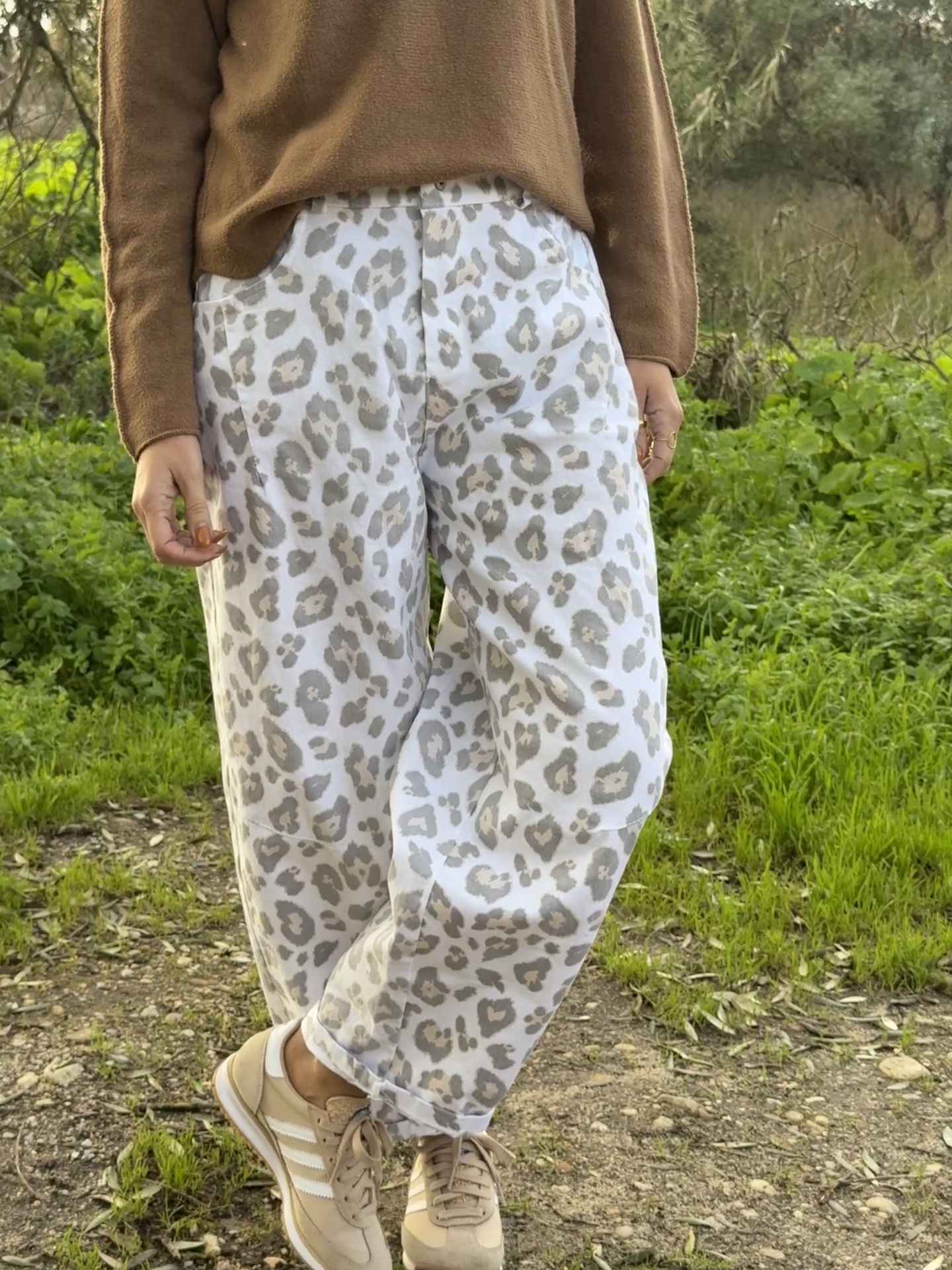 Calças femininas largas com padrão animal print cinzento e bege.