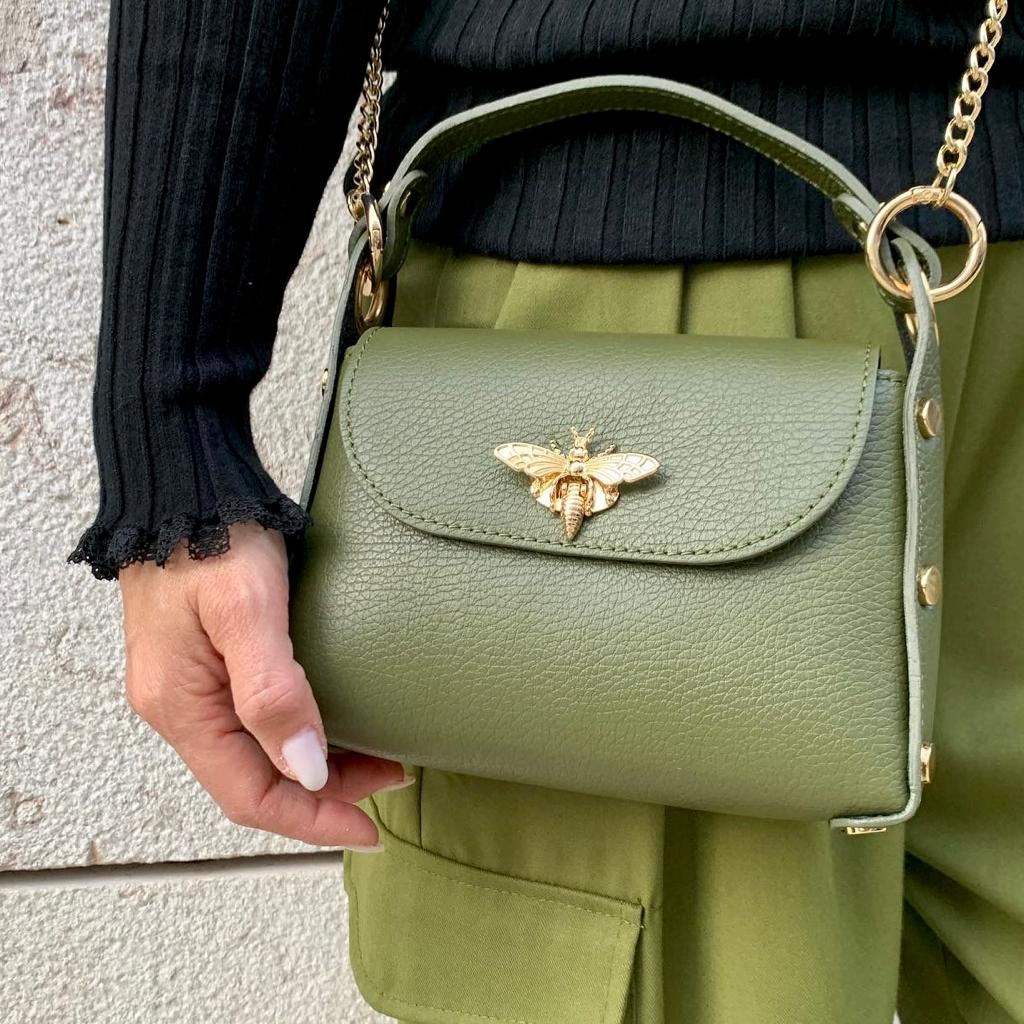 Mala de mão verde com fecho em forma de abelha e alça de corrente