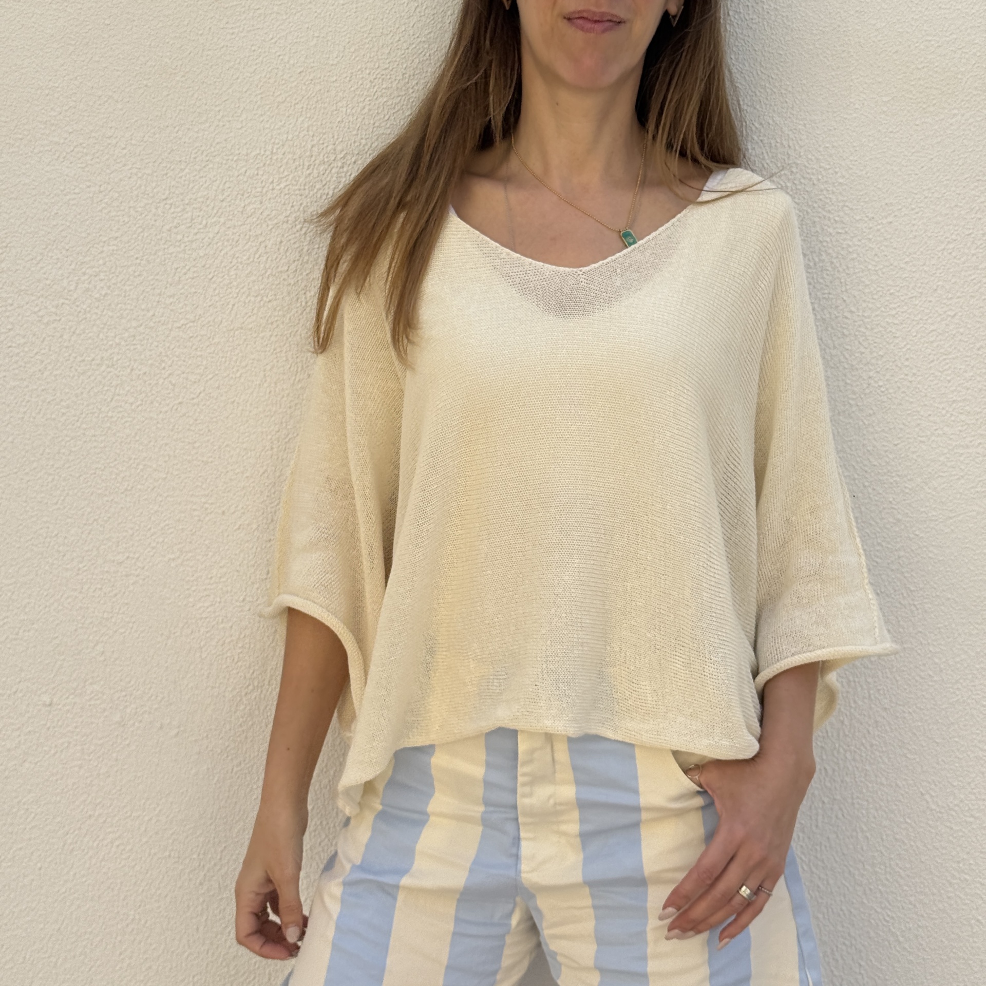 Blusa de malha bege clara com decote em V e mangas largas três quartos