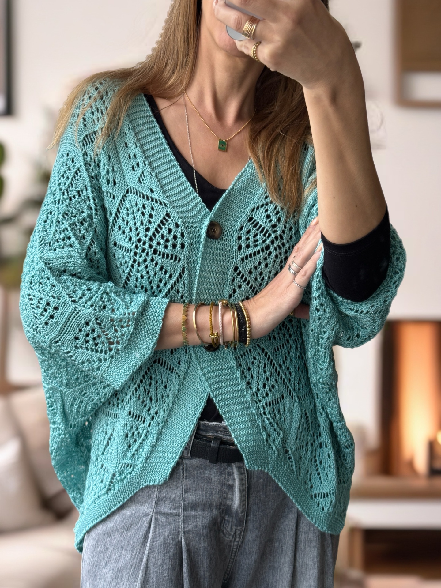 Cardigan tricotado azul turquesa com padrão rendado e botão castanho