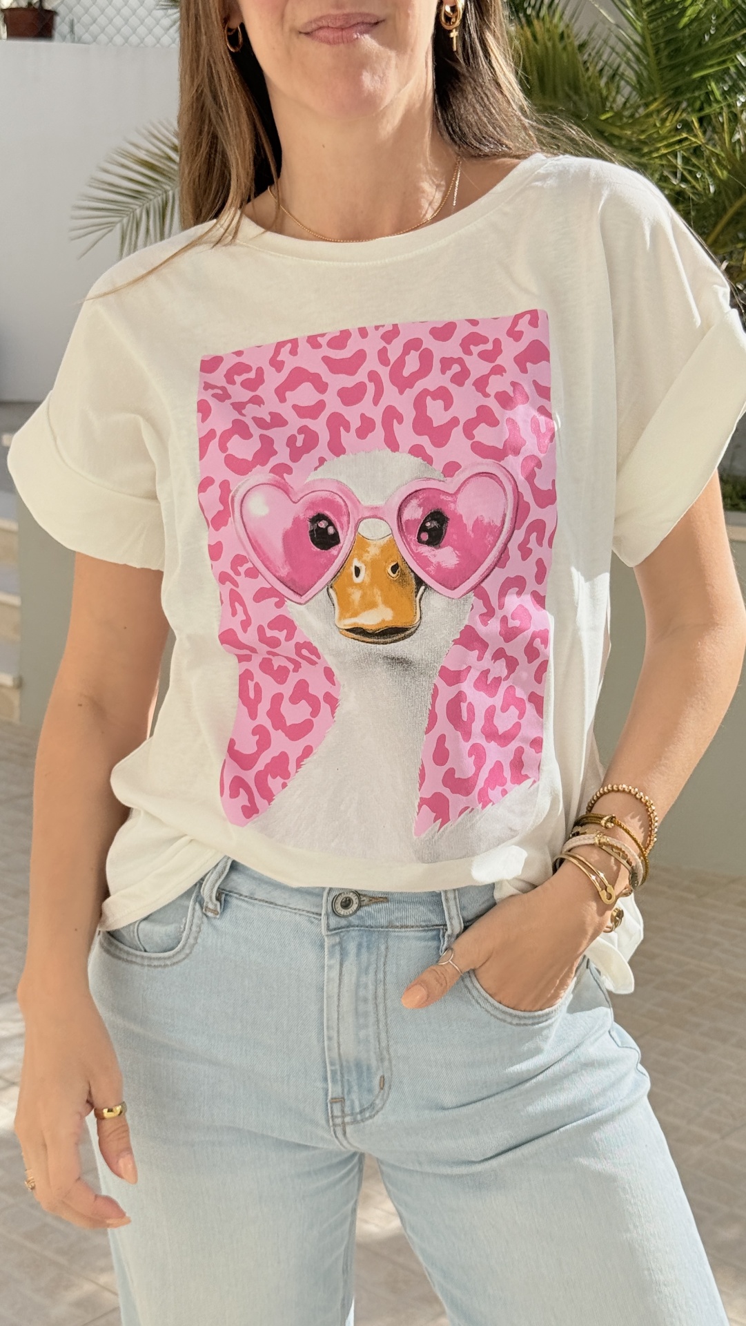 T-shirt creme com estampa de pato e óculos corações cor-de-rosa e jeans claros