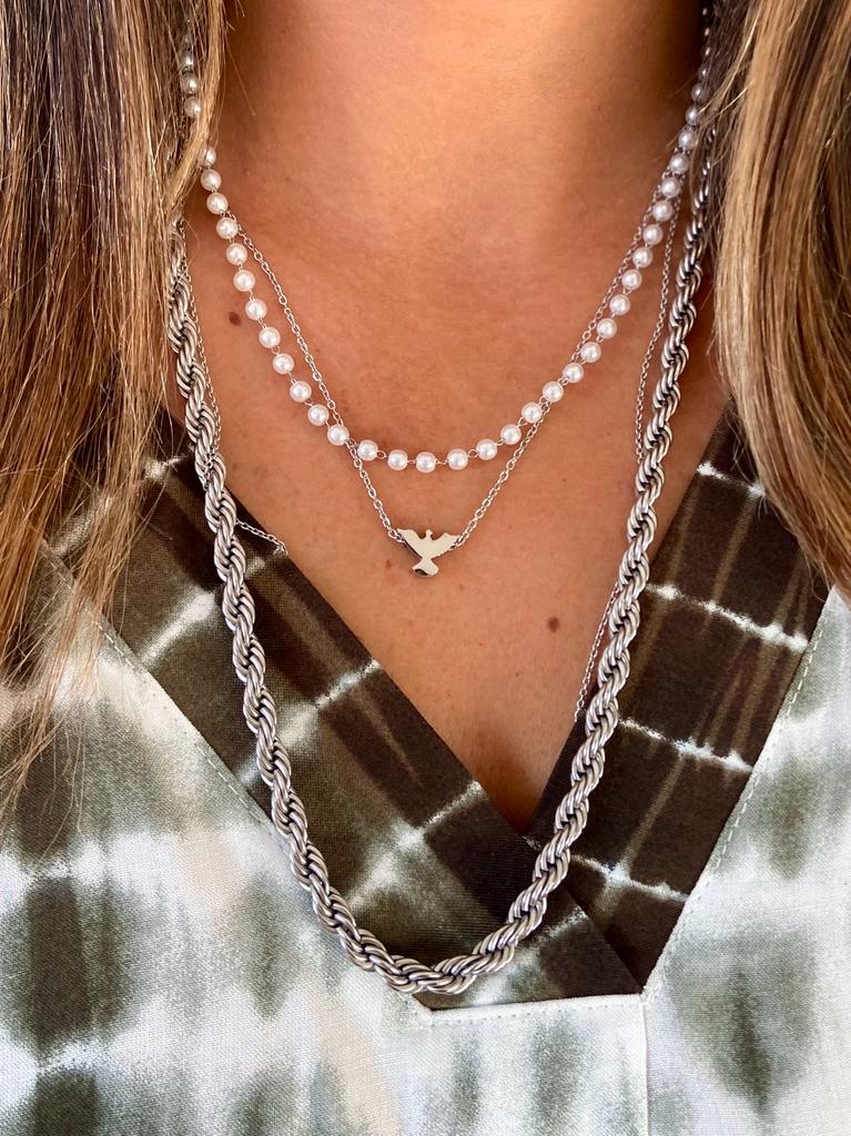 Colar triplo com corrente torcida, pérolas e pendente de pá sobre blusa tie-dye verde e branco