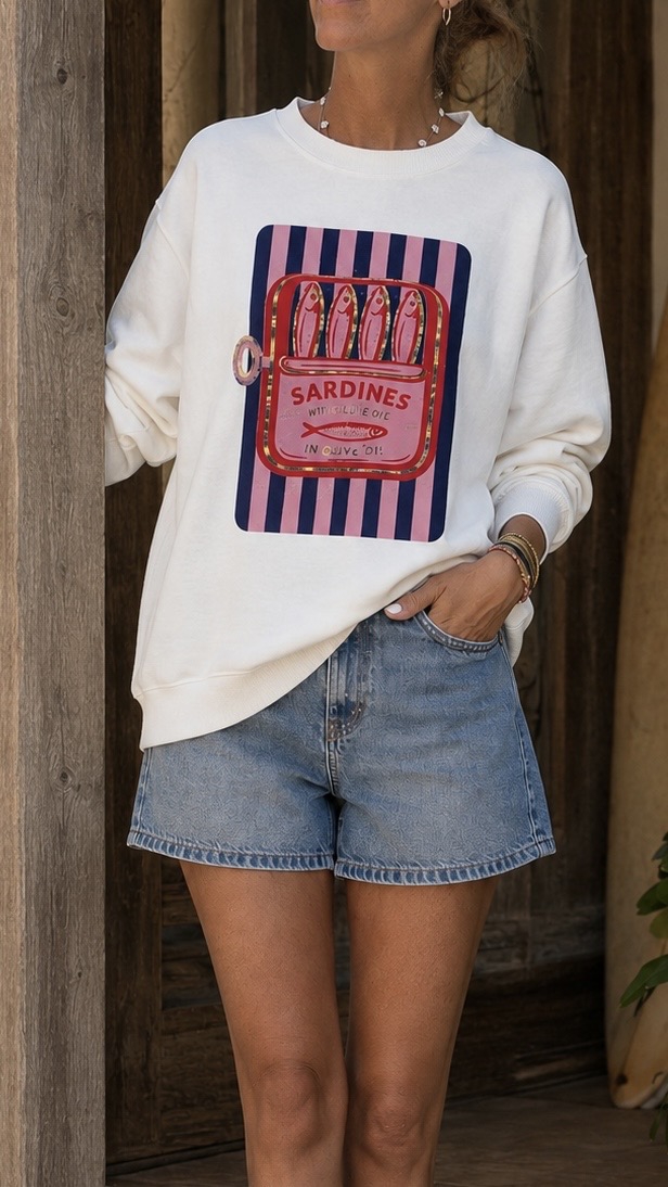 Sweatshirt branca com estampado de lata de sardinhas, calções de ganga azuis claros.