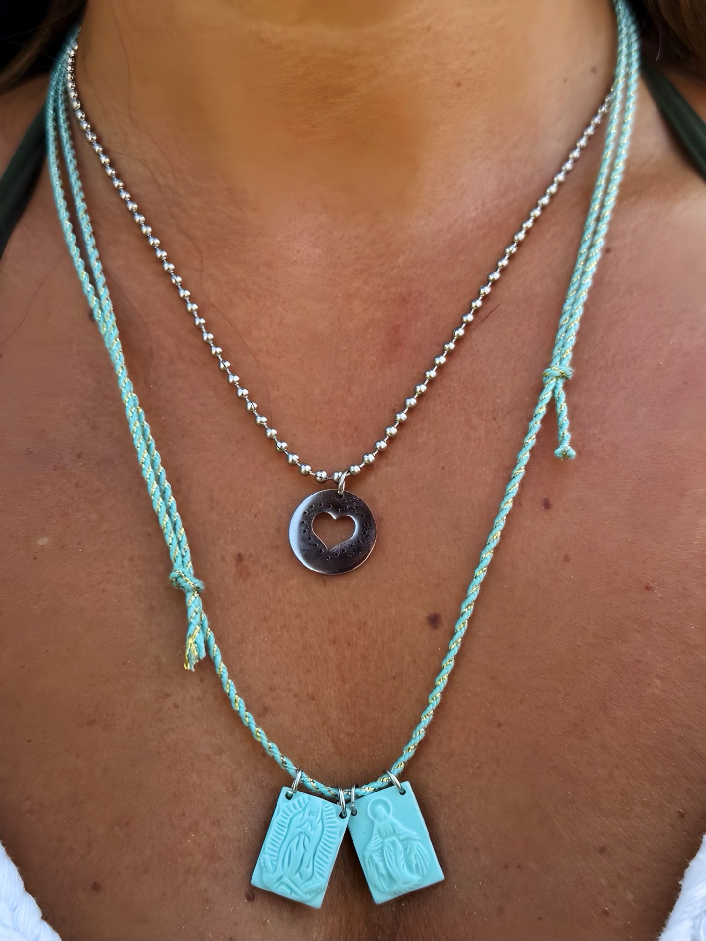 Colares com pendentes metálicos e azuis no pescoço