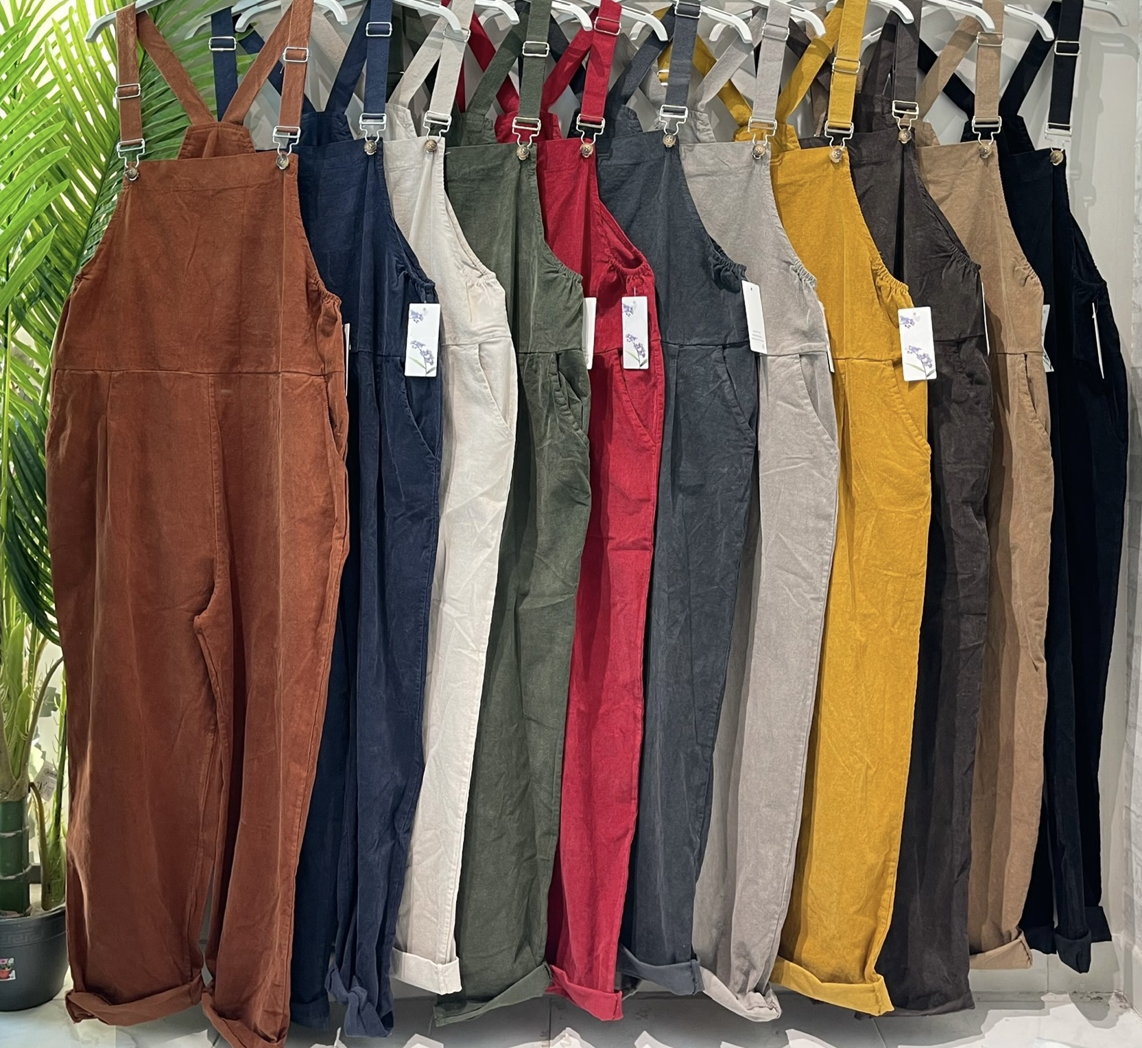 Macacões compridos de veludo cotelê em várias cores pendurados num cabide