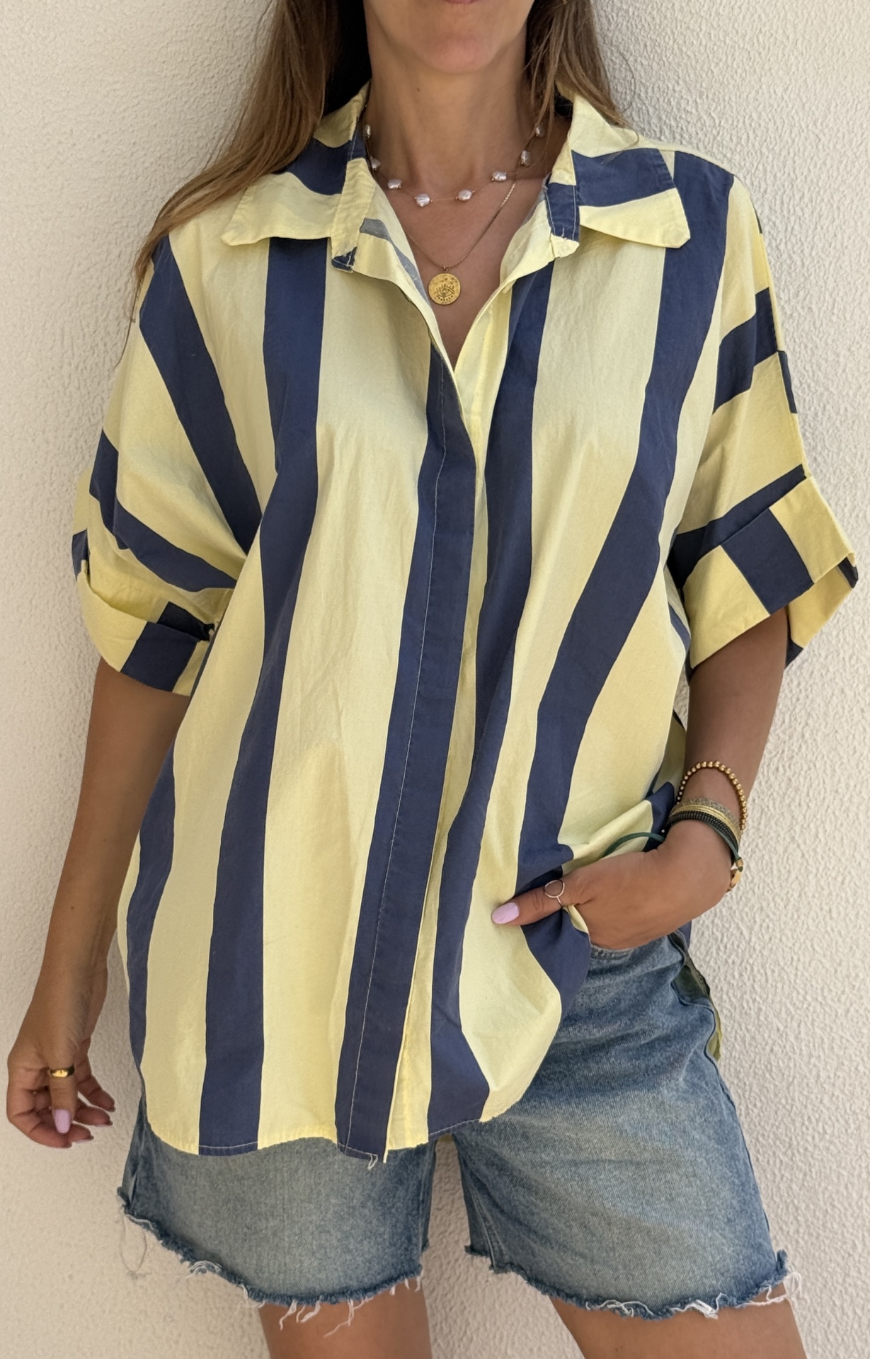 Camisa riscada amarela e azul com calções de ganga desfiados