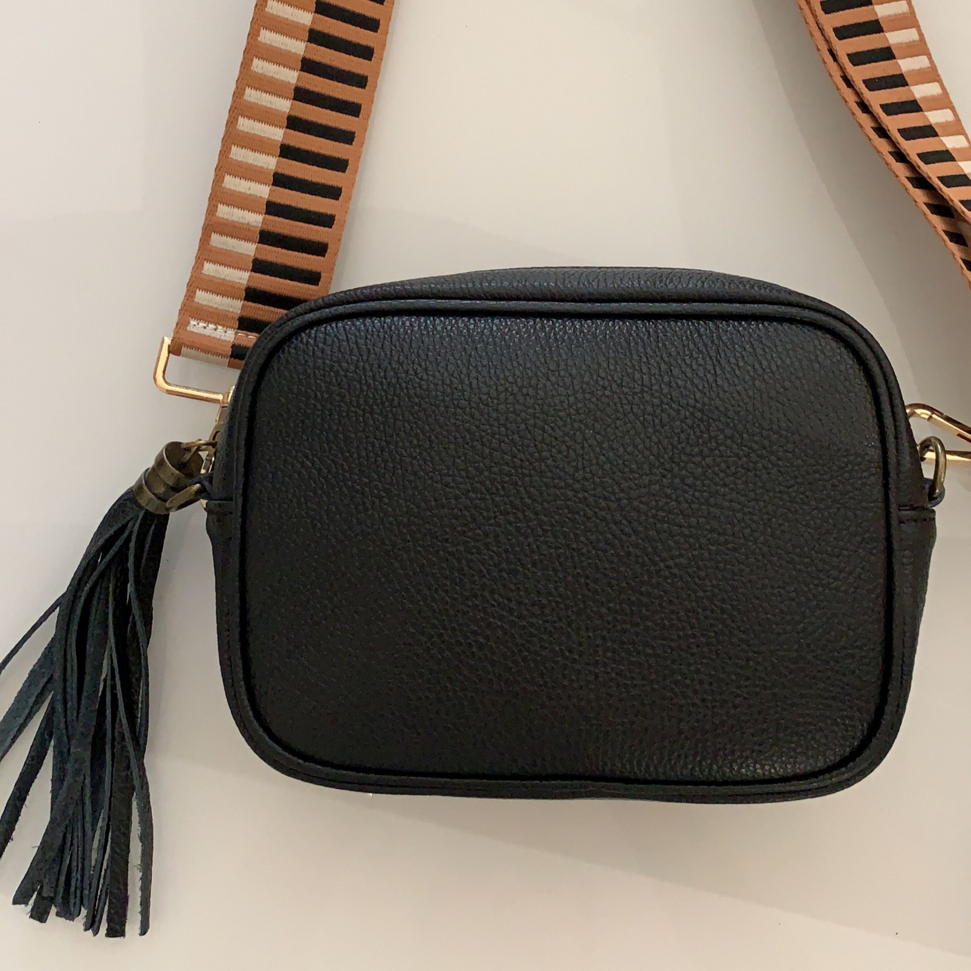 Mala preta retangular com alça larga castanha às riscas e franjas pretas