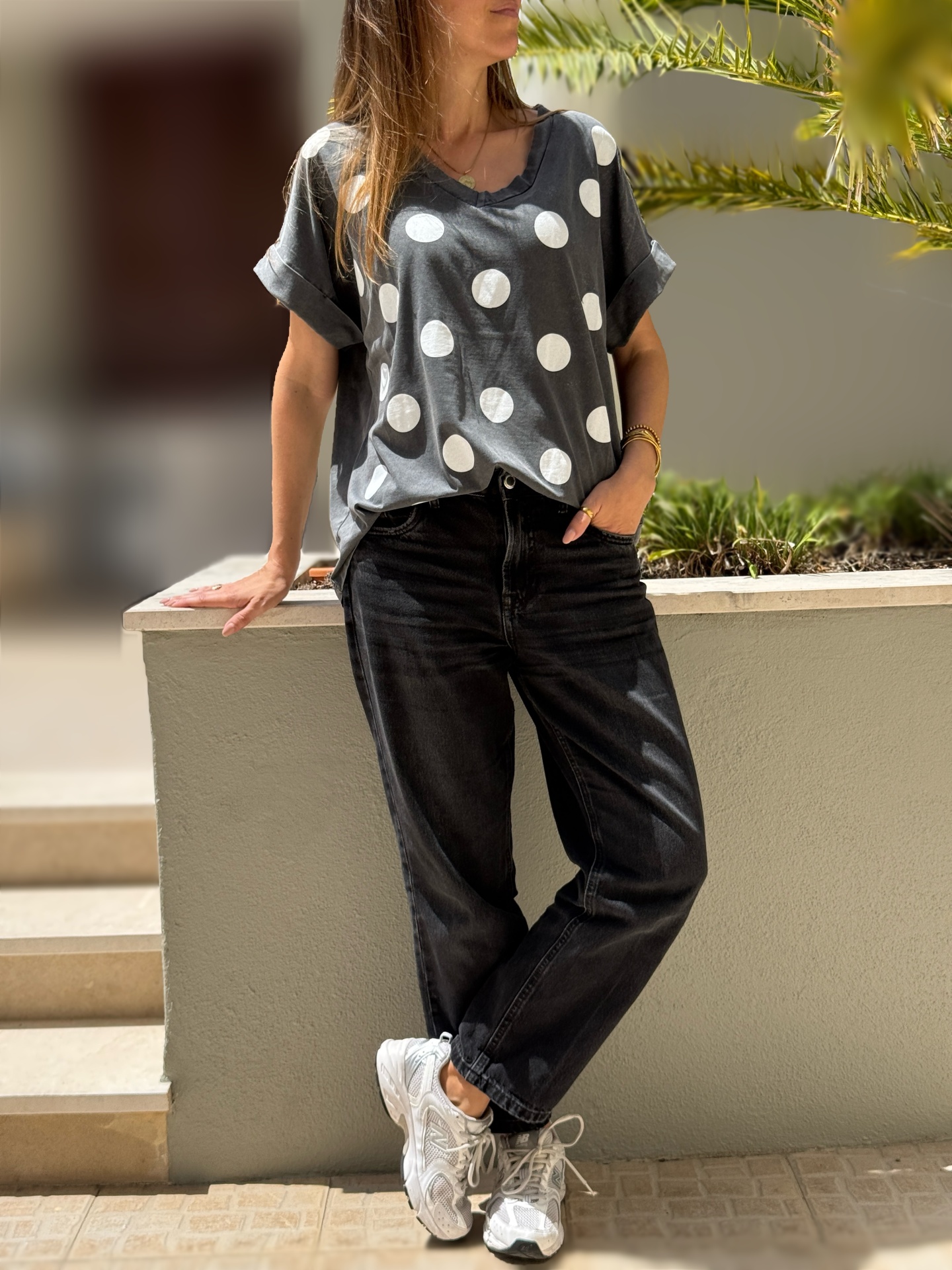T-shirt cinzenta com bolinhas brancas e calças pretas de ganga largas com sapatilhas brancas
