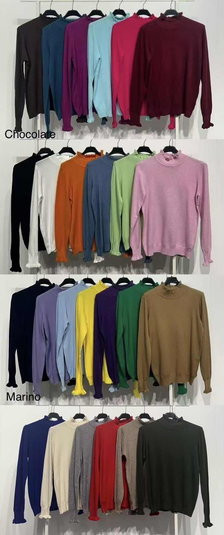 Várias camisolas de cores diferentes penduradas em cabides, com gola e punhos franzidos, organizadas em quatro grupos, com etiquetas 'Chocolate' e 'Marino' no fundo branco.