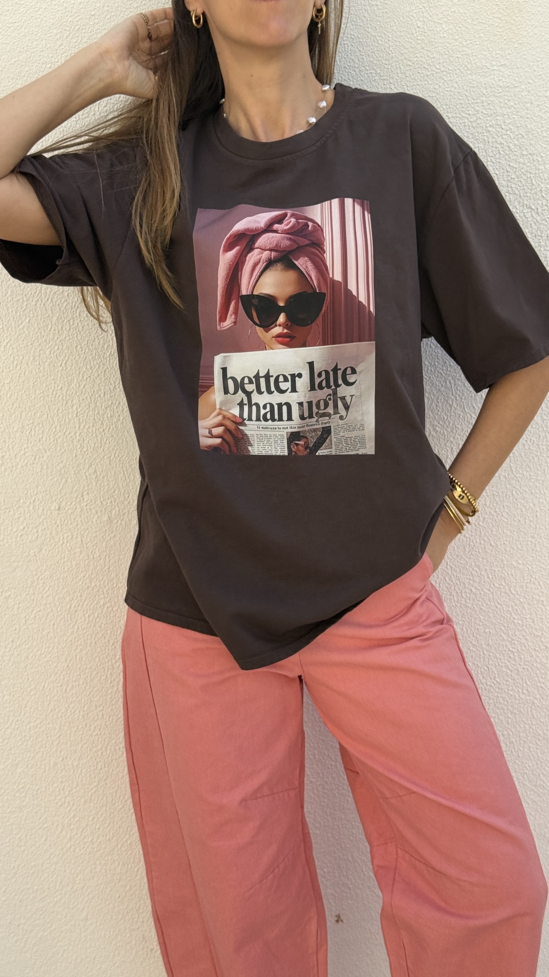 Mulher com t-shirt preta com estampa colorida e calças salmão