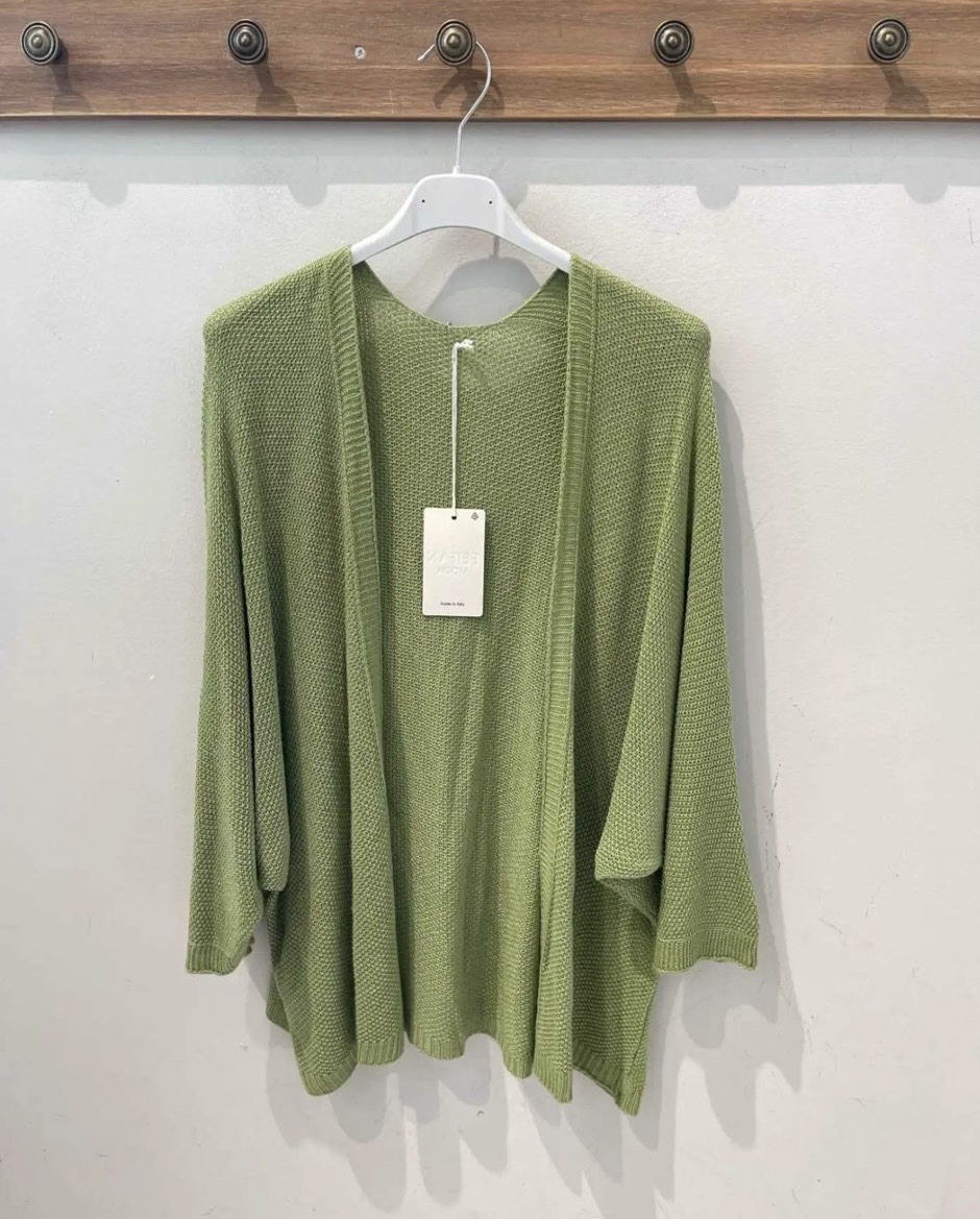 Casaco de malha verde clara pendurado num cabide branco